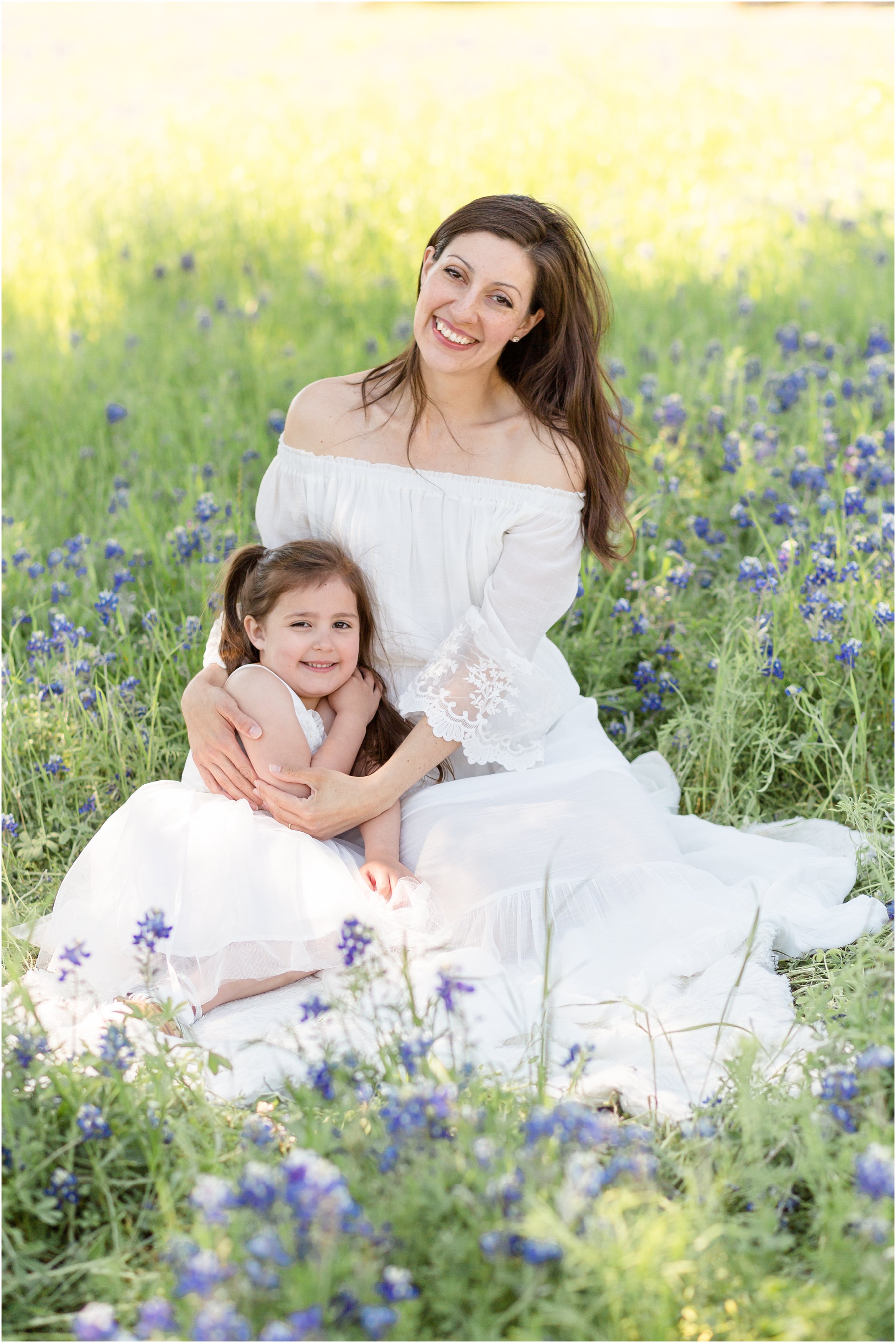 mom and daughter in white dresses in bluebonnet field