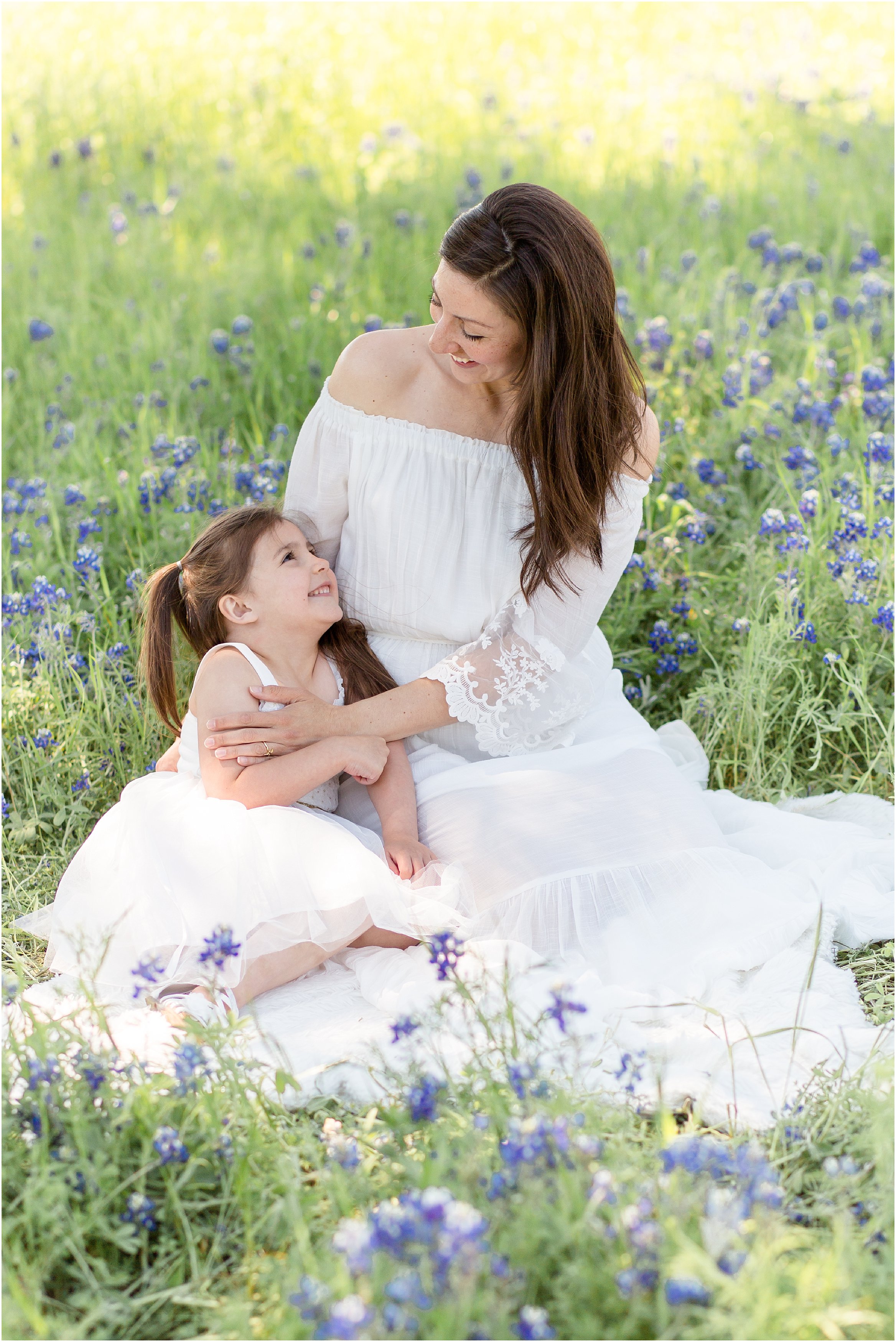 mom and daughter in white dresses in bluebonnet field