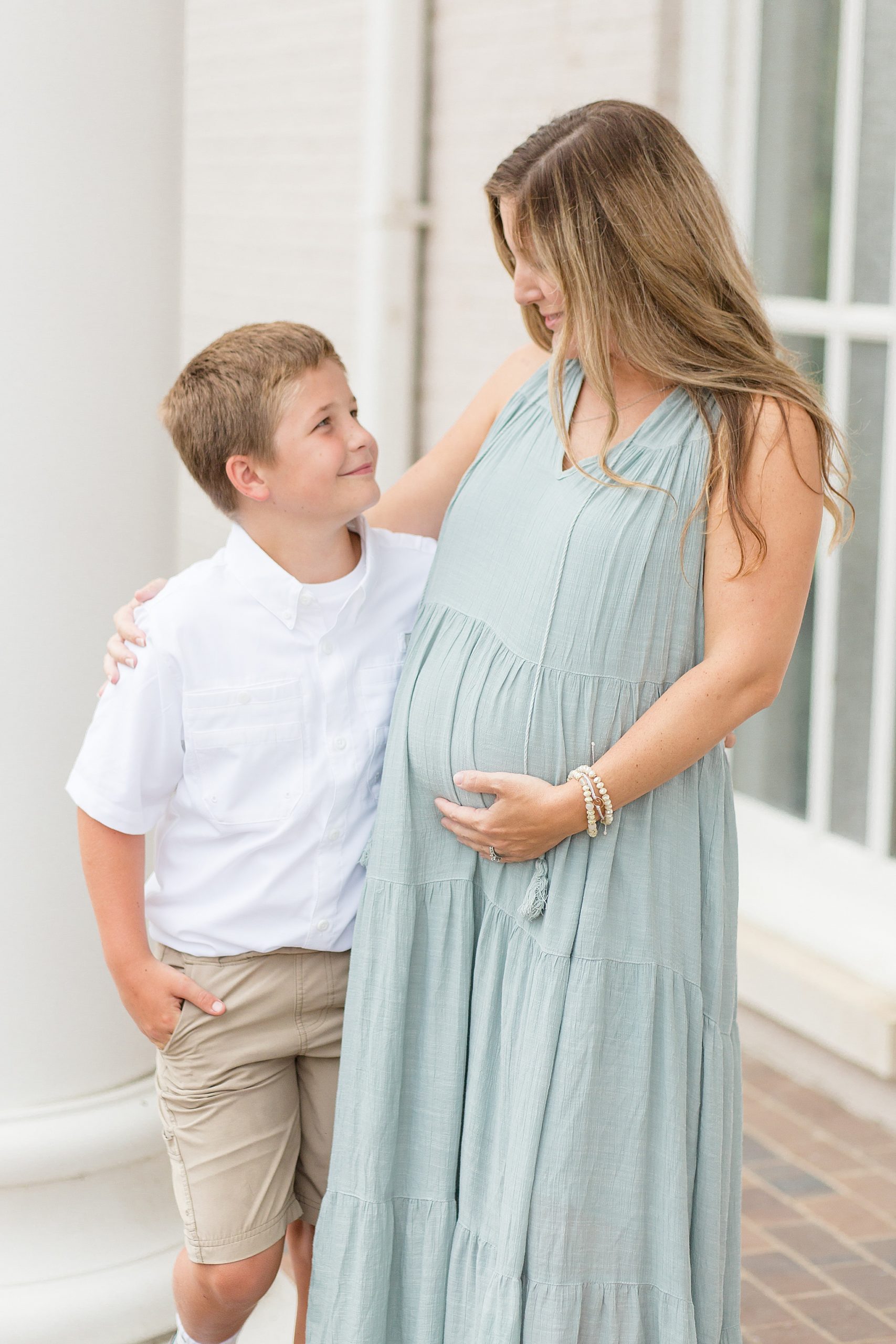 mom holds belly while talking to son