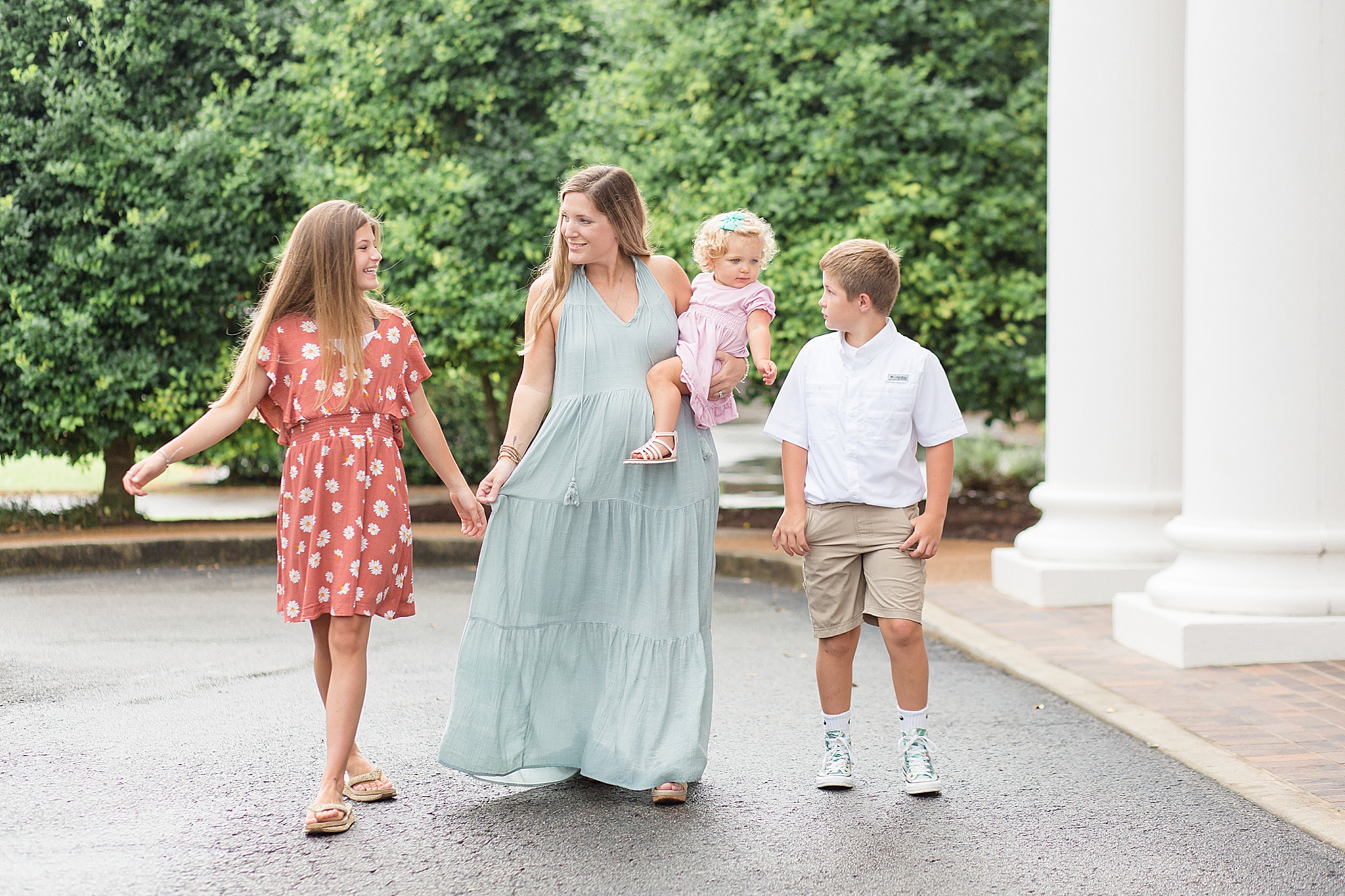 pregnant mom walks with three kids outside church