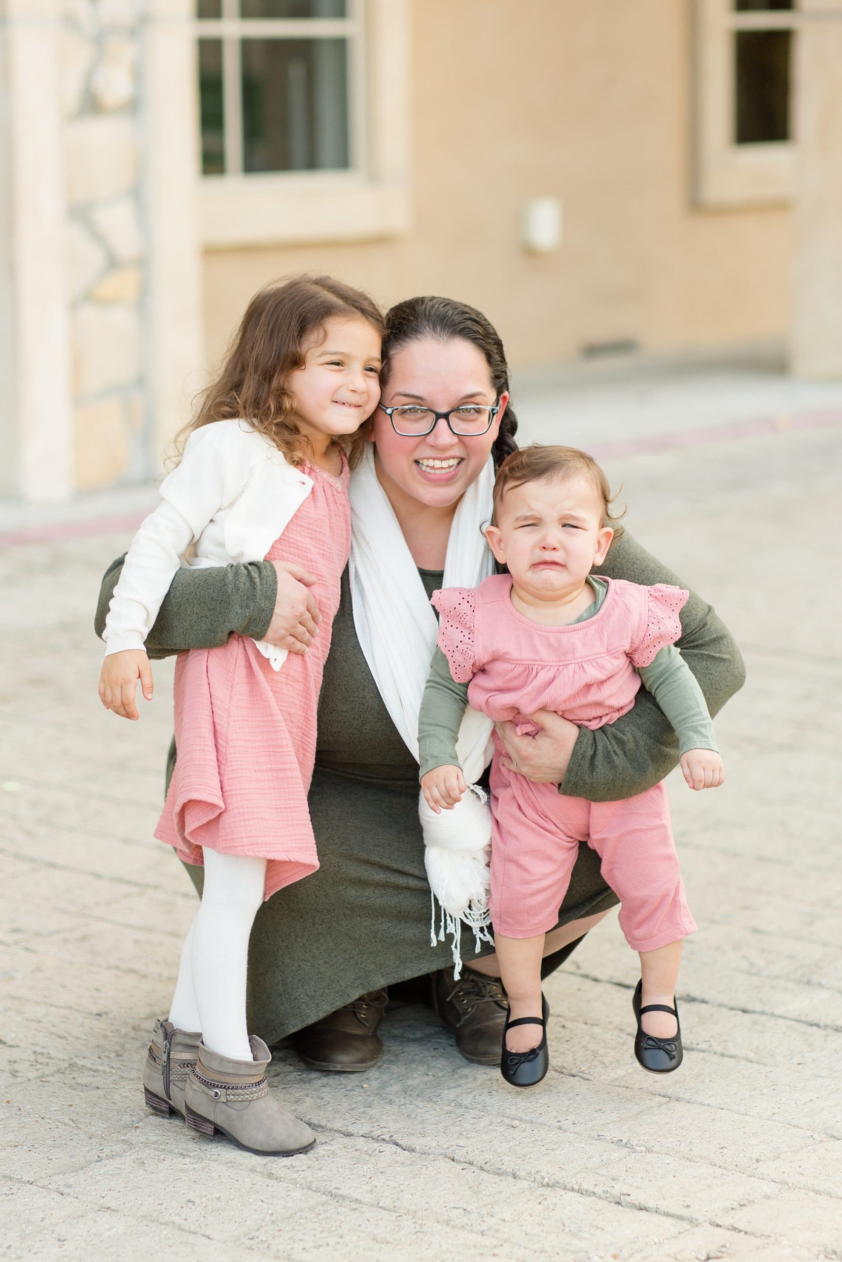 mom holds daughters in pink outfits during TX family session