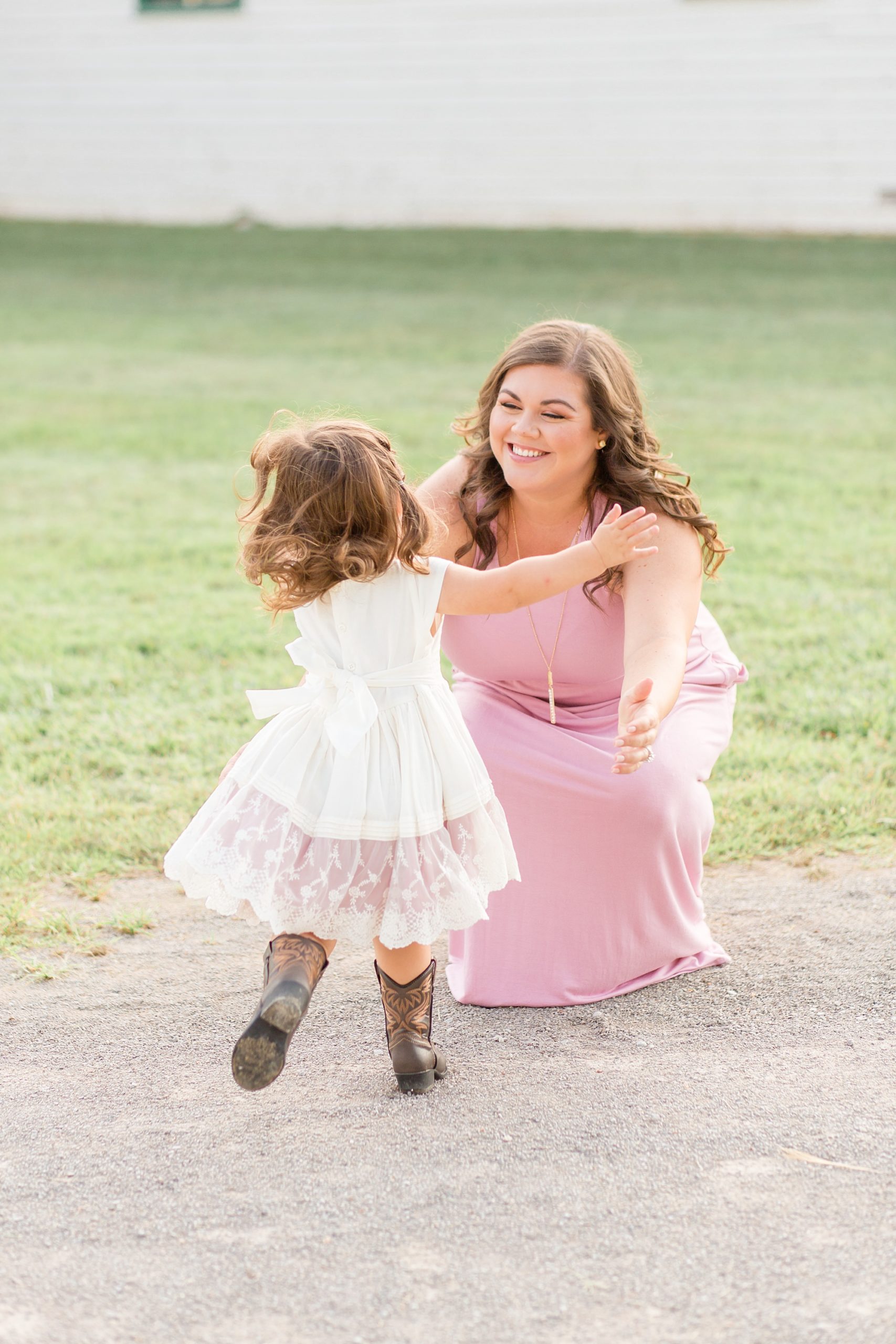 daughter runs towards mom in pastel pink gown