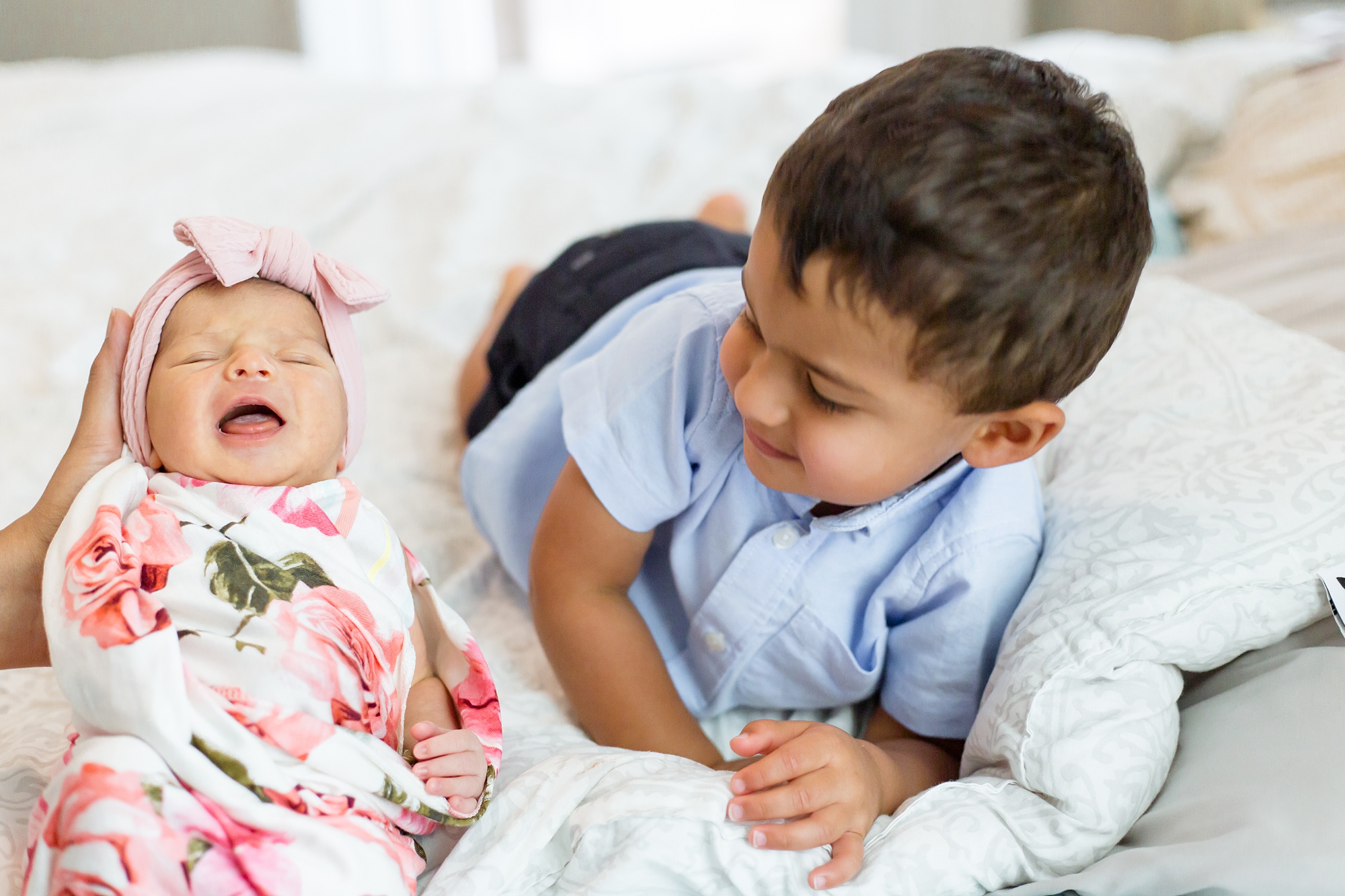 toddler and newborn pose on bed during Lifestyle Newborn Session