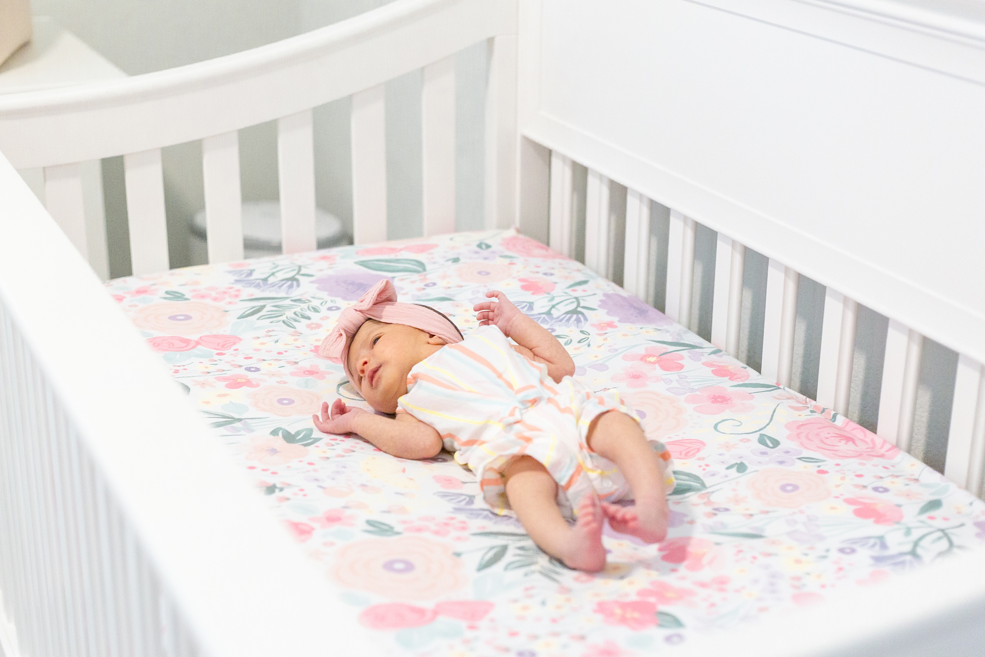 baby girl lays in crib during Lifestyle Newborn Session