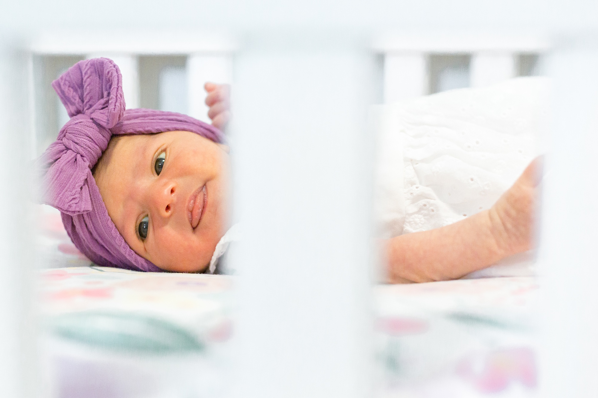 newborn baby girl lays in crib during Lifestyle Newborn Session