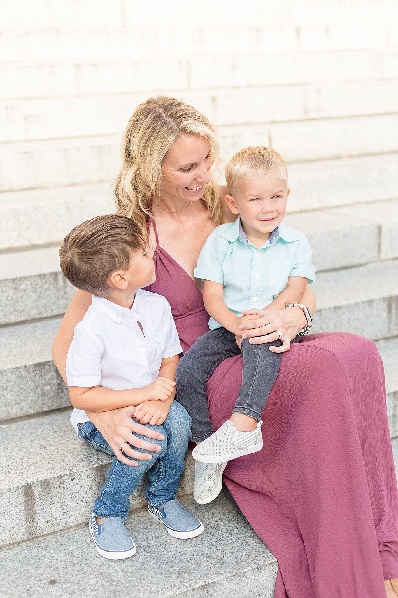 mom and two sons sit on steps at Nashville War Memorial