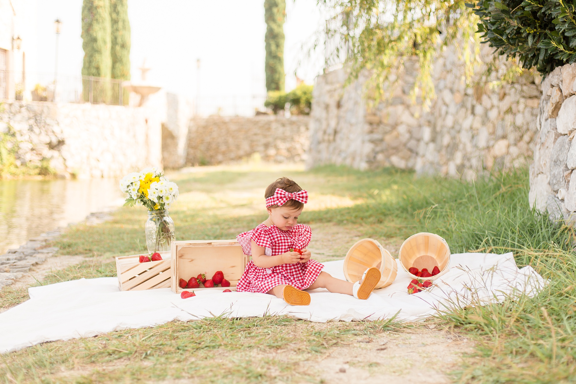 baby eats strawberries during Adriatica Village 1st Birthday photos