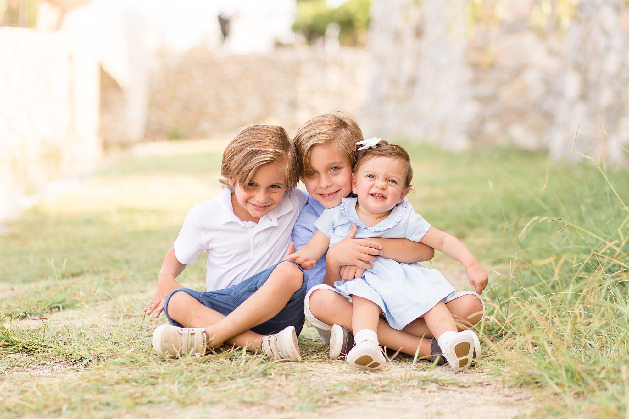 brothers hold sister during Adriatica Village family photos