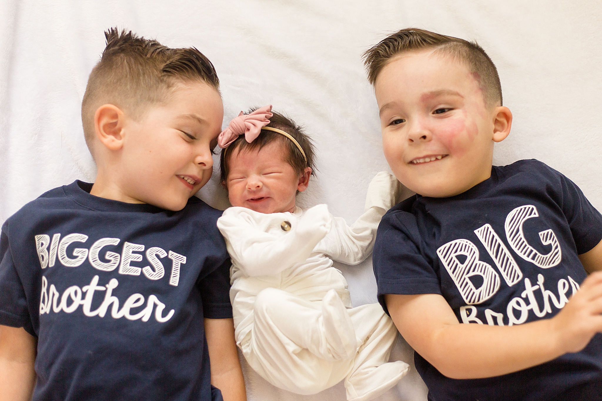 brothers pose with new baby sister during at home newborn portraits
