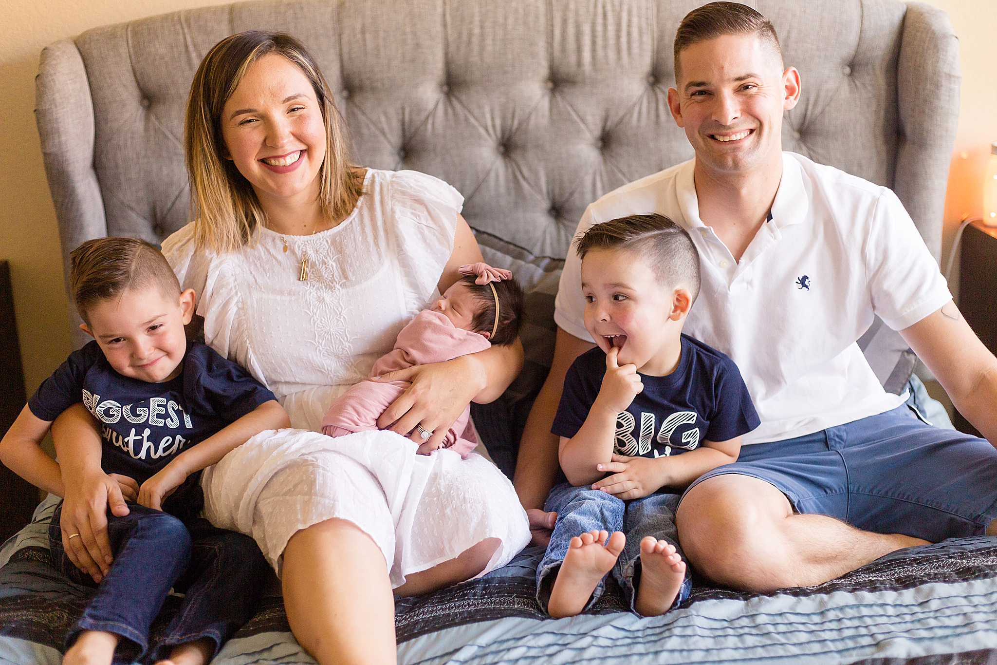 family of five sits on parents bed during At Home Lifestyle Newborn Session