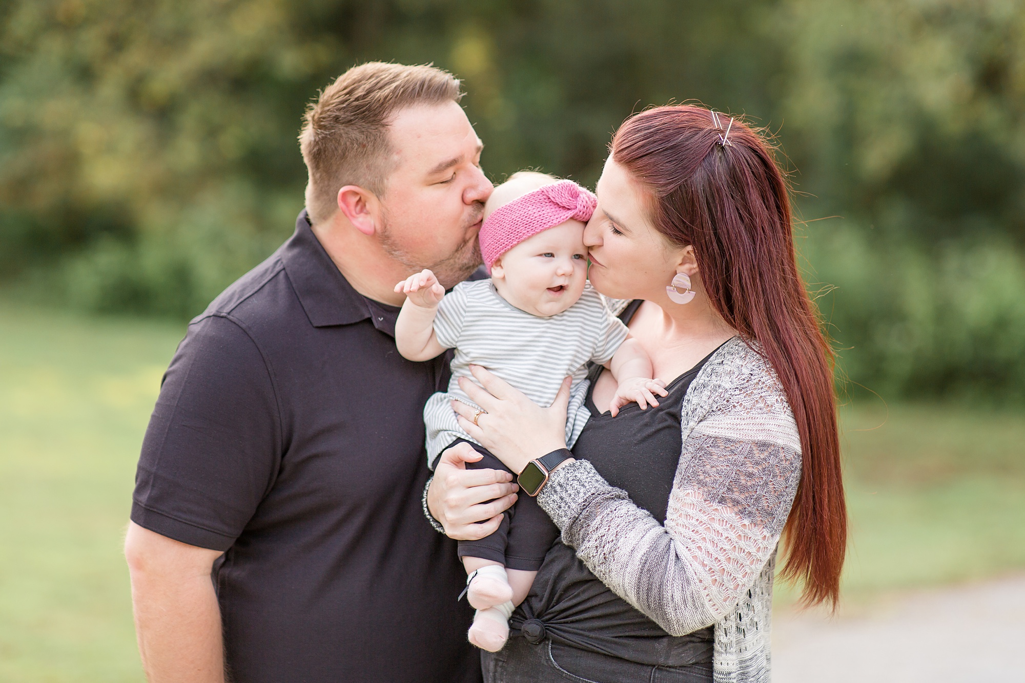 parents kiss toddler during Tennessee family portraits