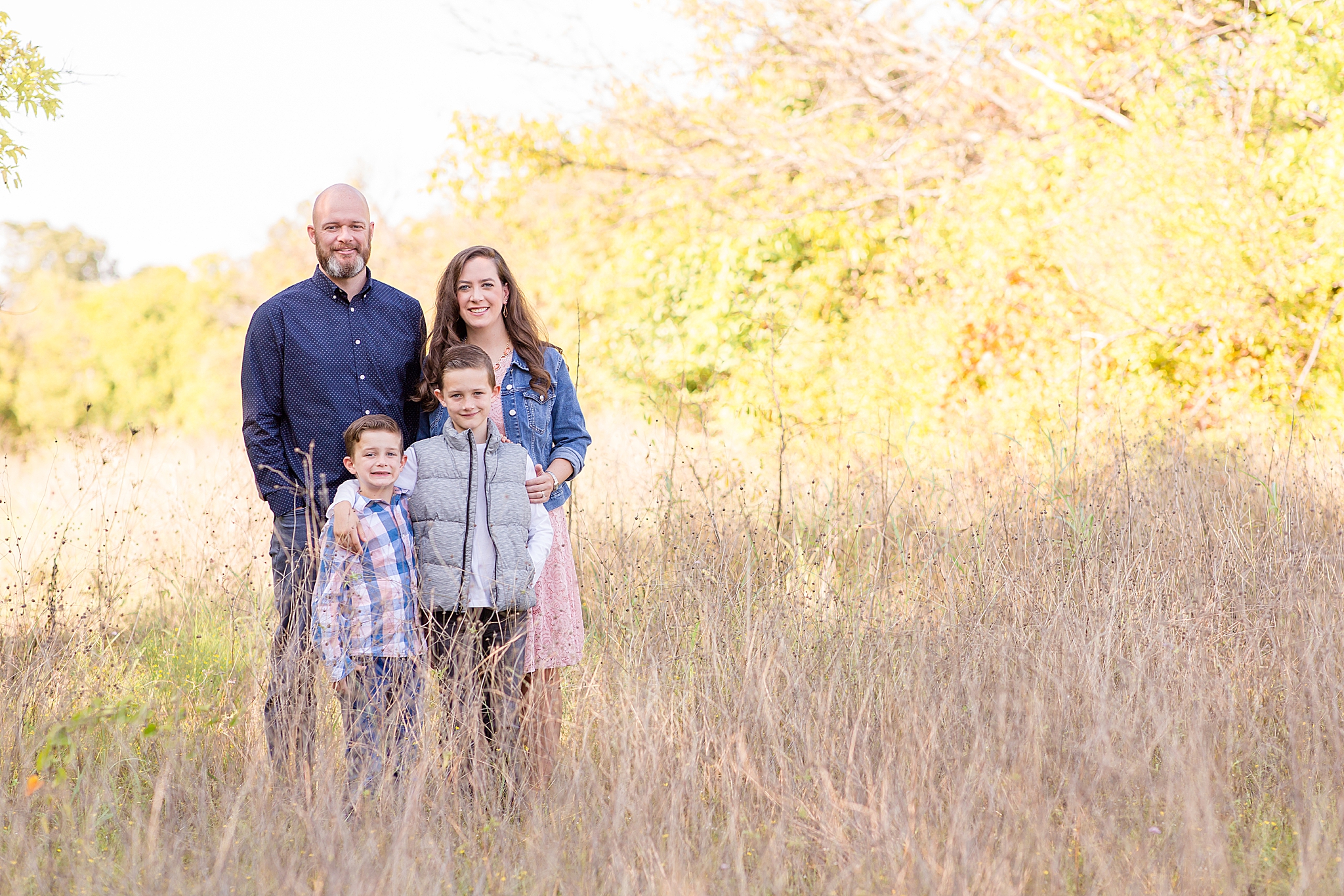 family of four poses in field during Frisco Commons Fall Minis