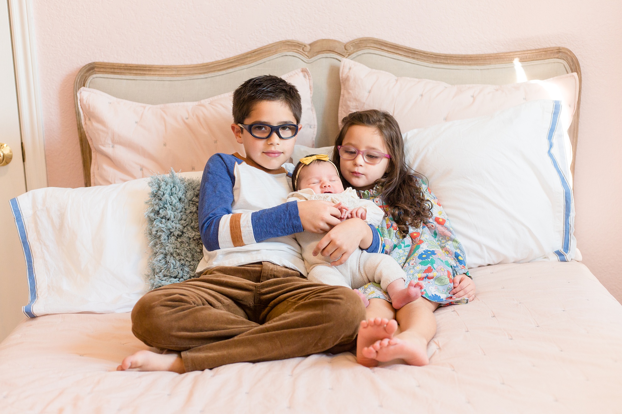 big siblings hold new baby during lifestyle newborn session
