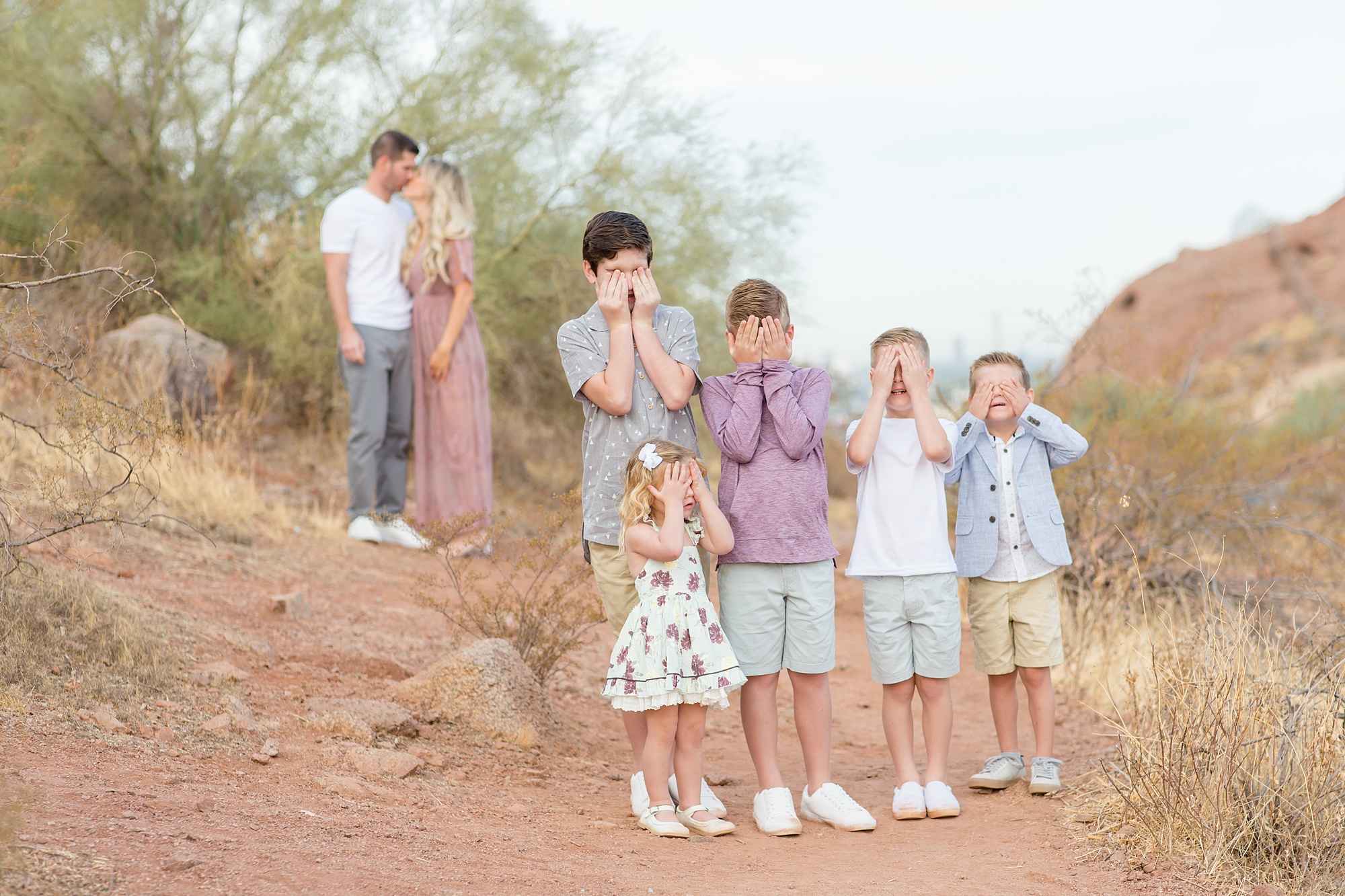 four kids cover eyes while their parents kiss during Papago Park Fall Minis