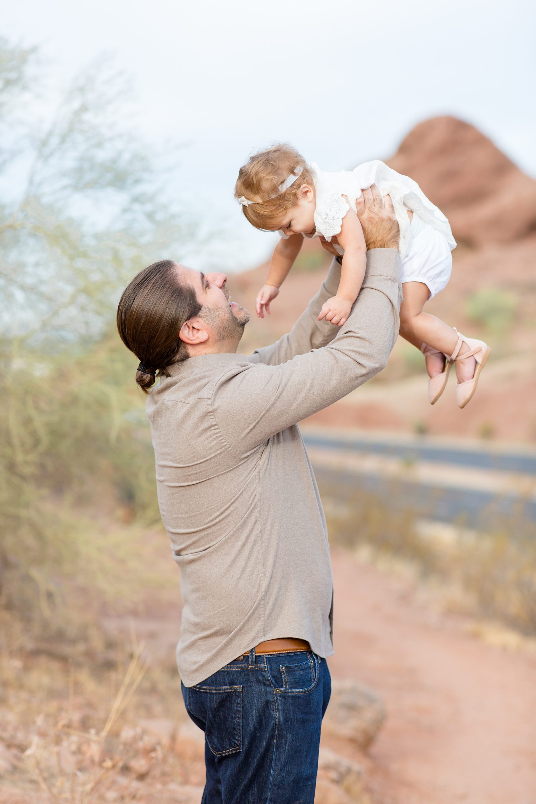 dad lifts toddler during photos in Papago Park