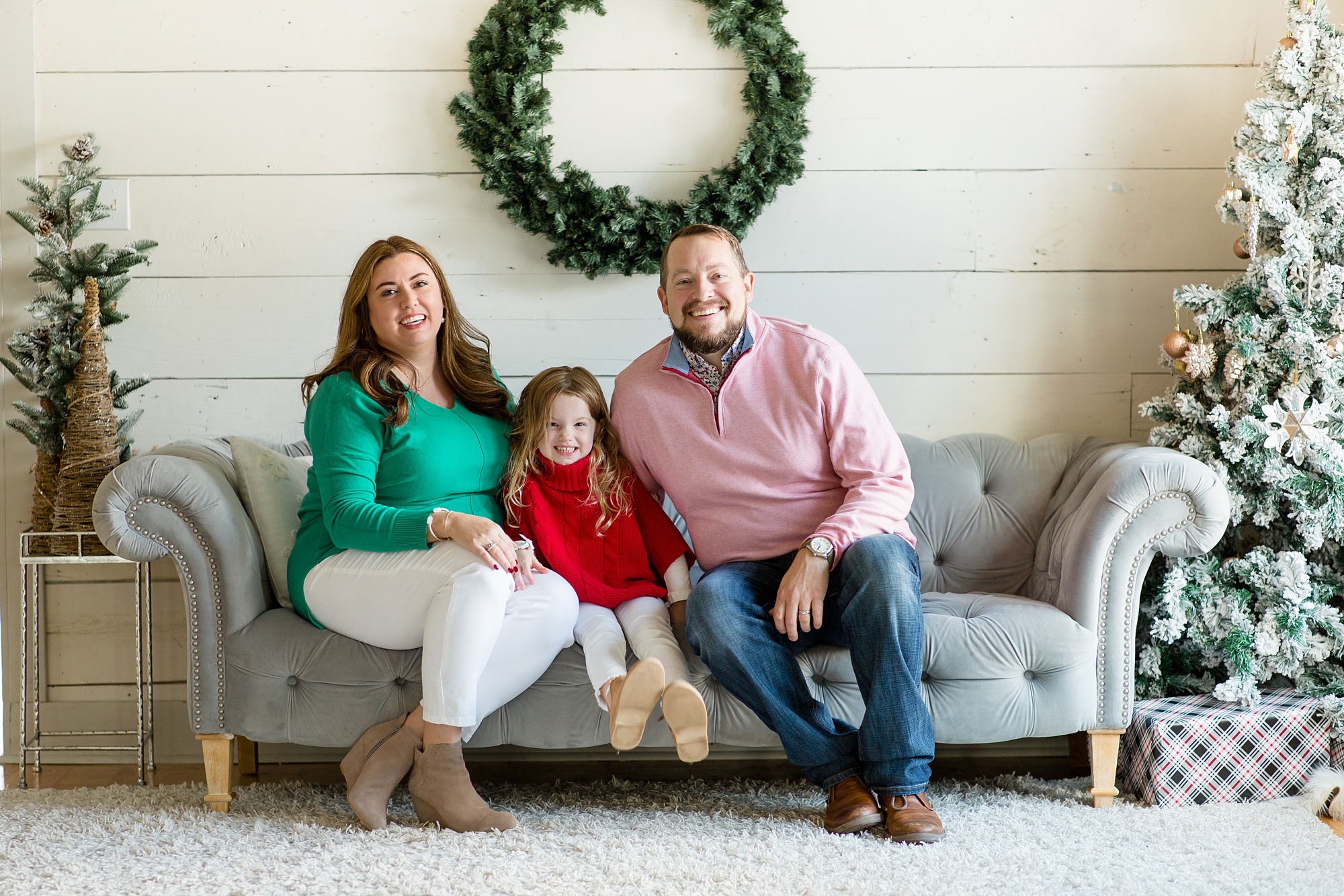 family poses on couch during Studio House Christmas Minis