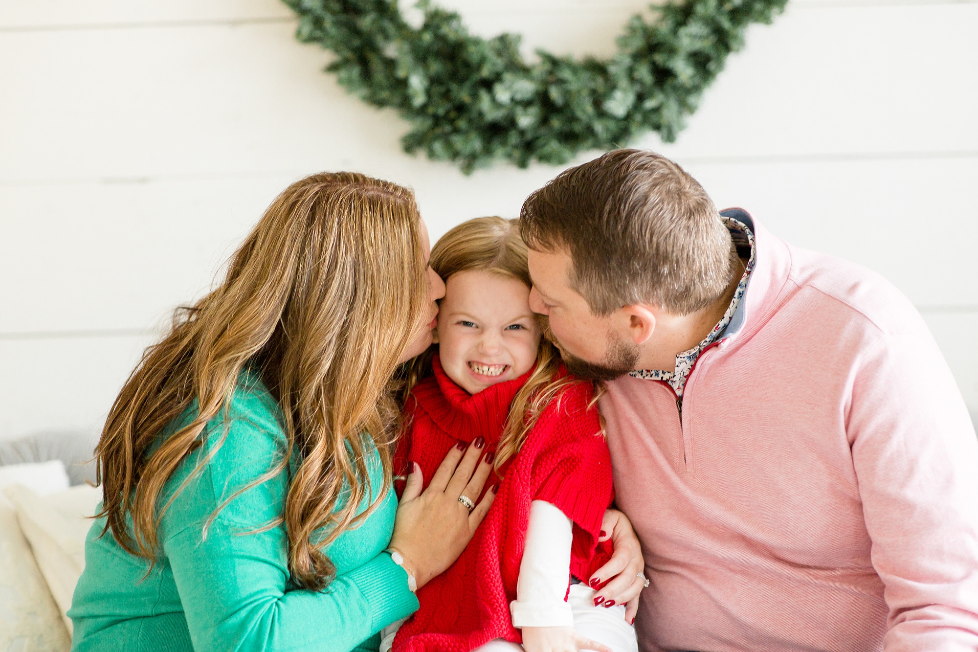 parents kiss daughter's cheeks during holiday mini sessions