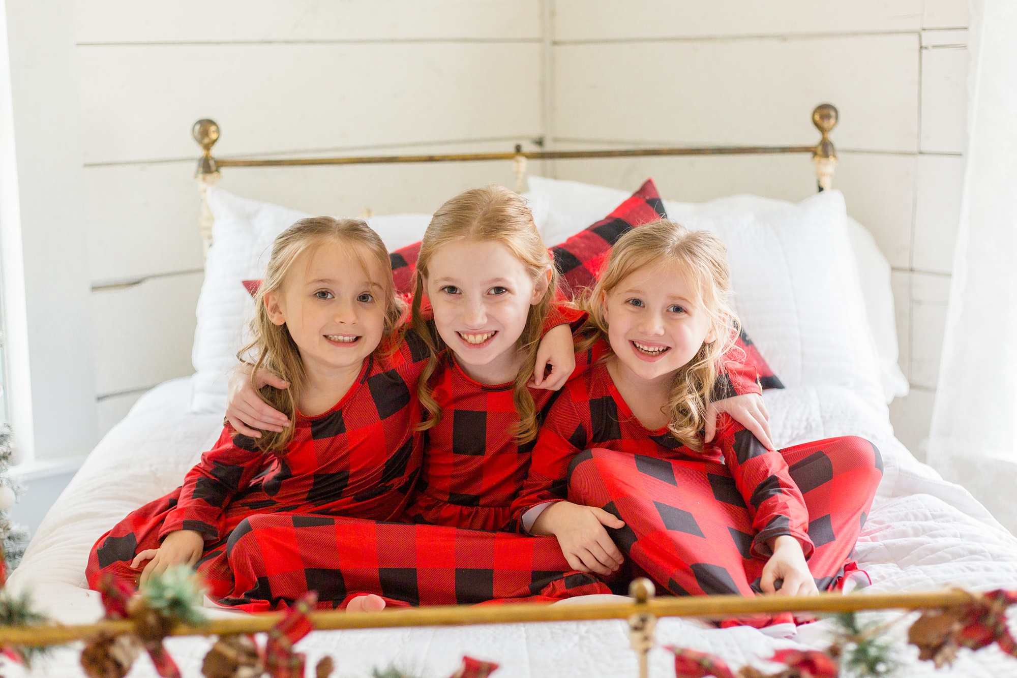 siblings in red and black buffalo plaid PJs pose for Studio House Christmas Minis