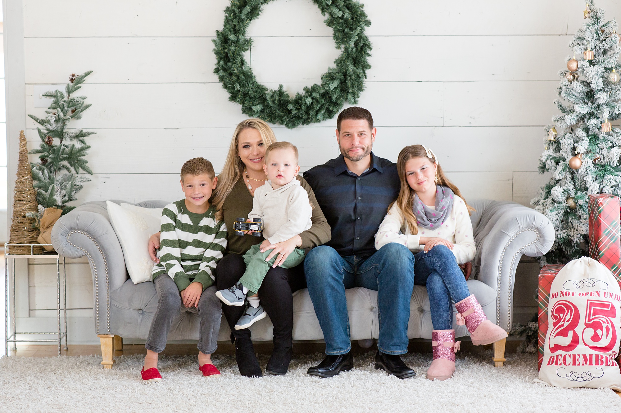 family of five sits on couch during Studio House Christmas Minis
