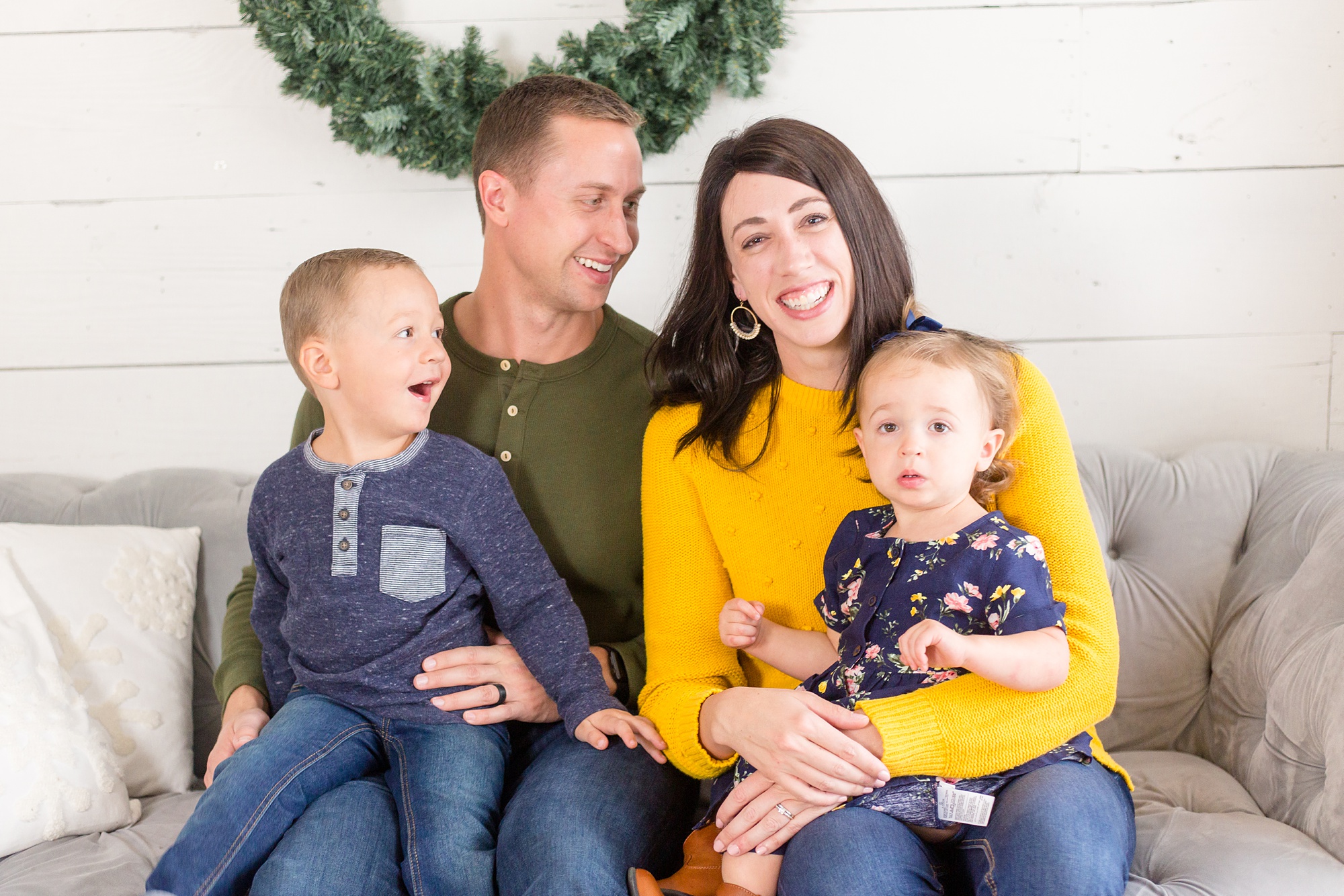 family of four sits on couch during TX mini session