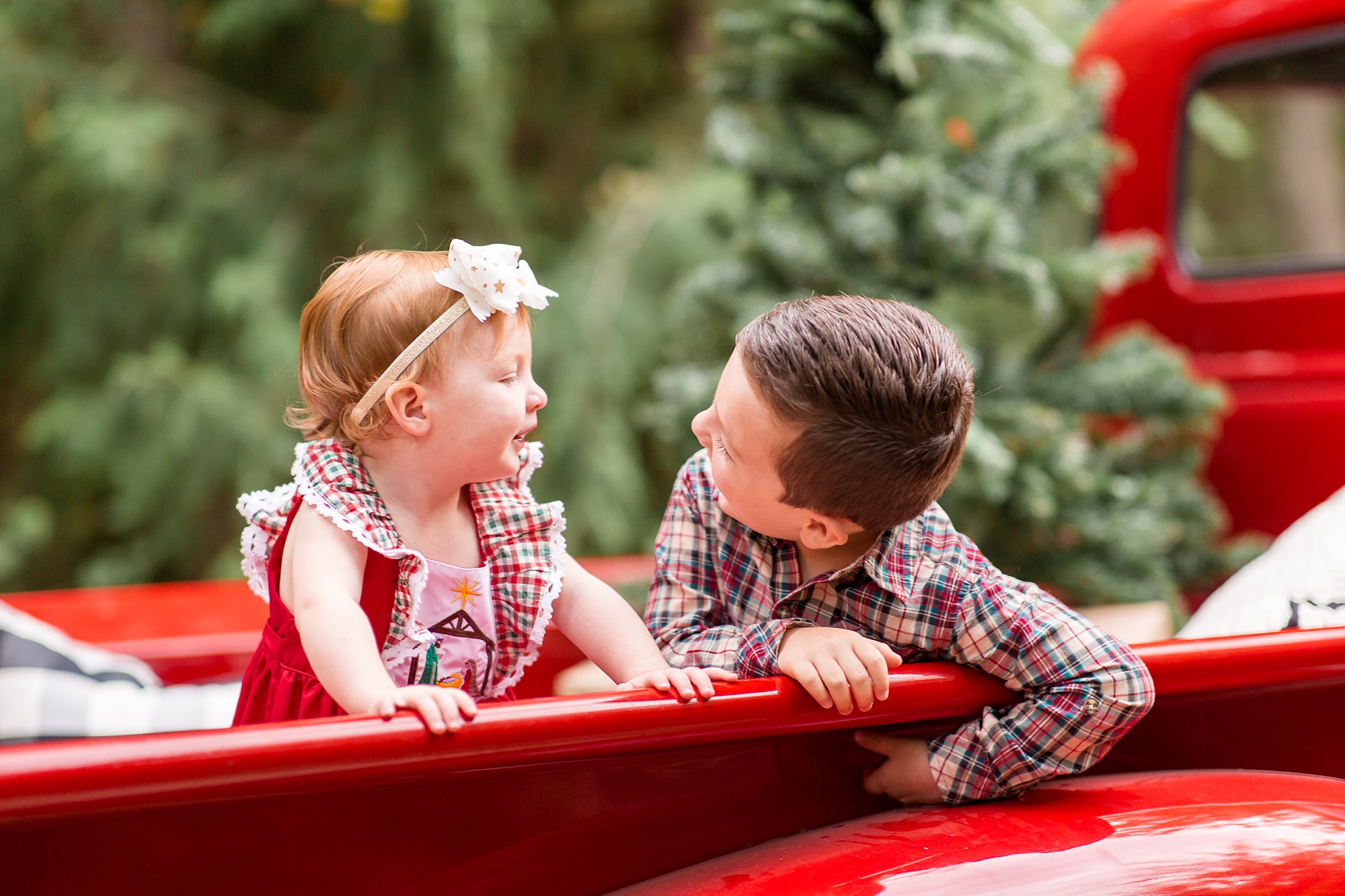 brother makes sister laugh during holiday photos