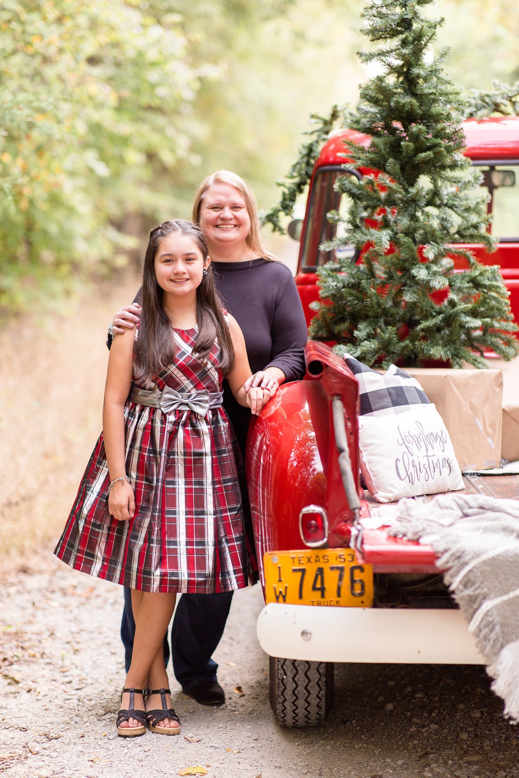 mom and daughter pose by truck during TX Christmas minis