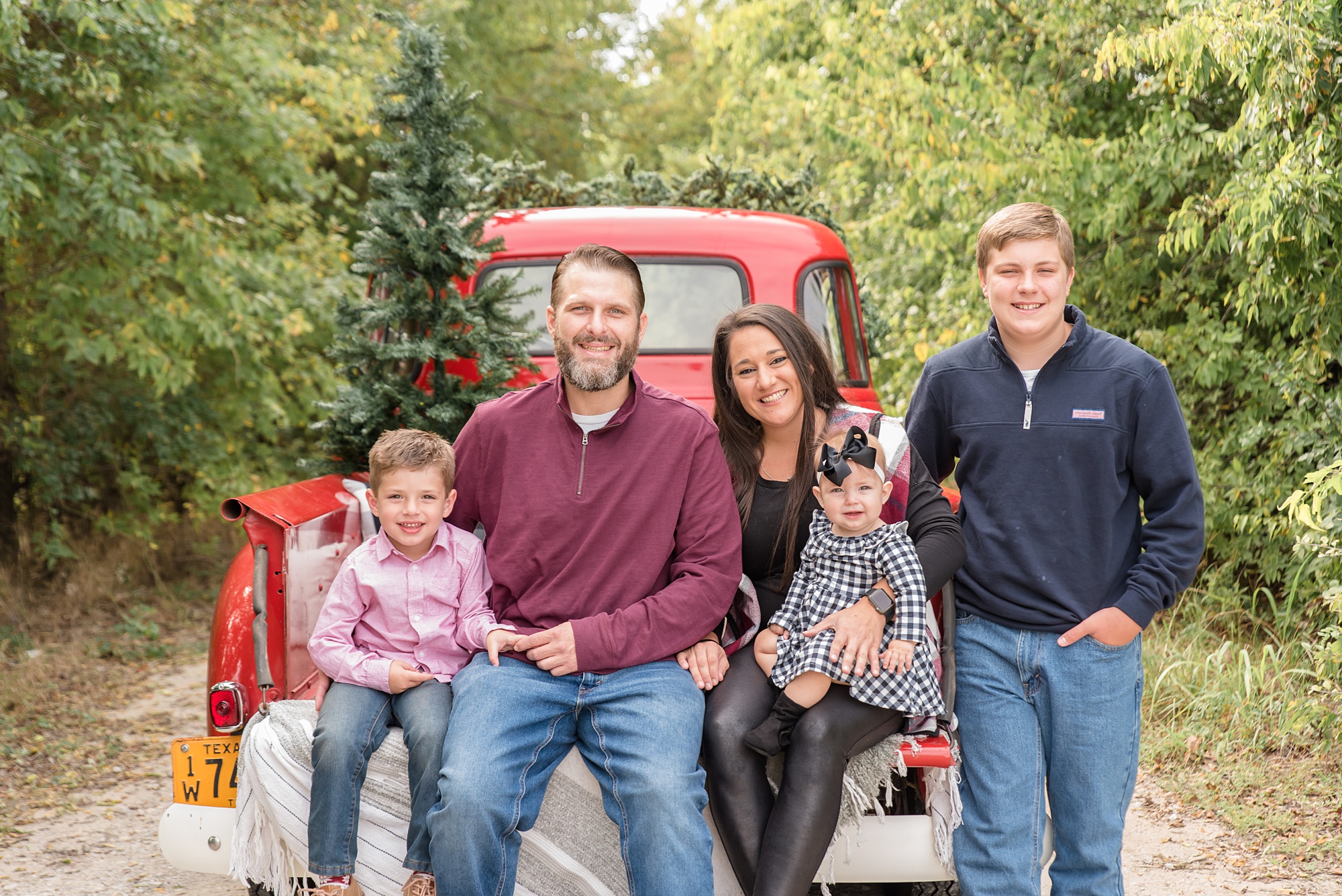family poses together during Red Truck Christmas minis