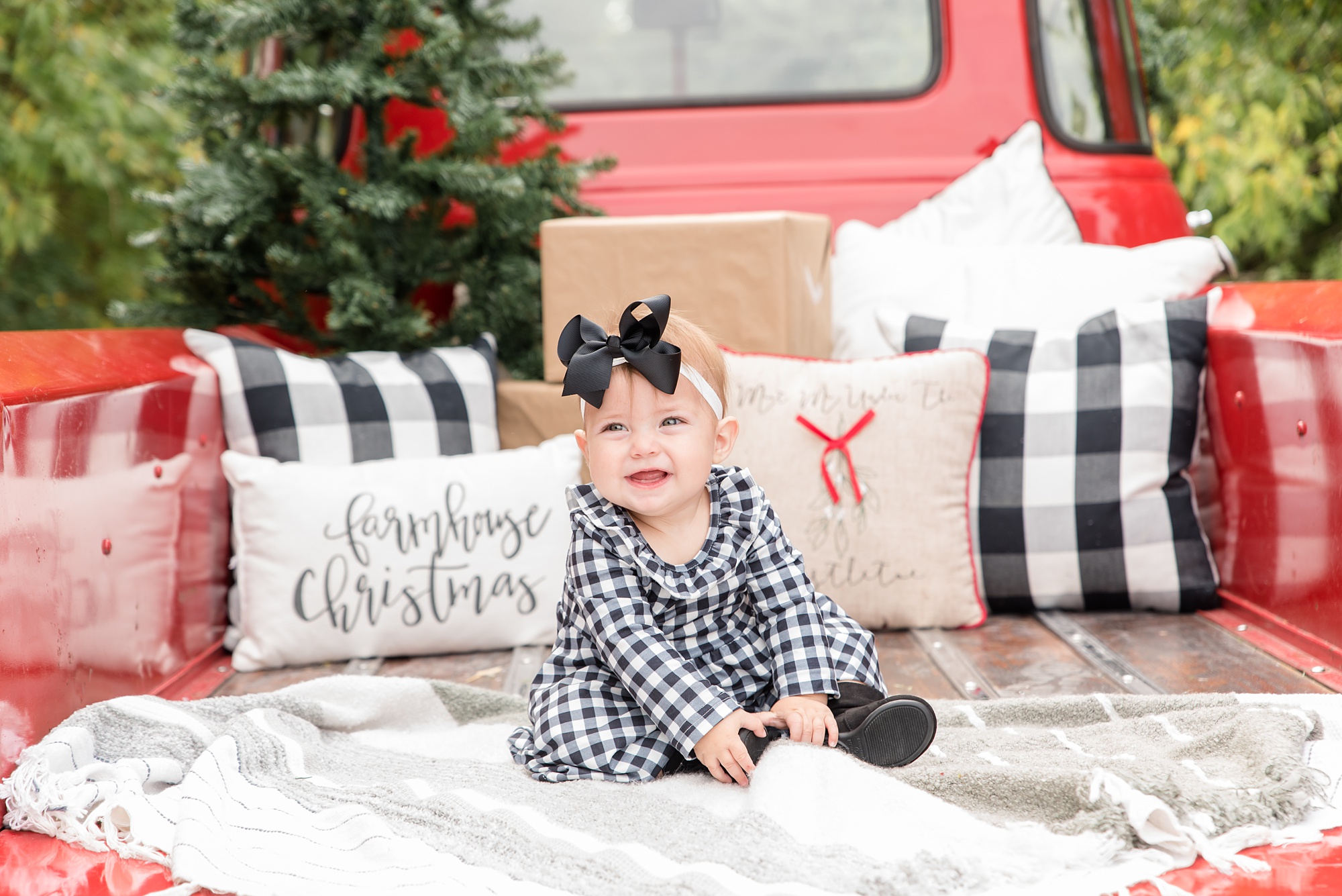 little girl sits on truck bed during Red Truck Christmas minis