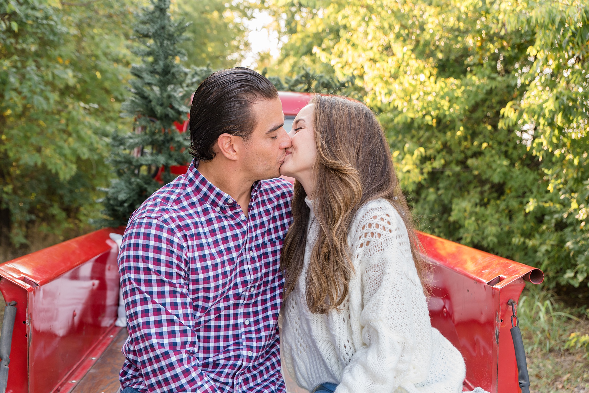 parents kiss during Red Truck Christmas minis