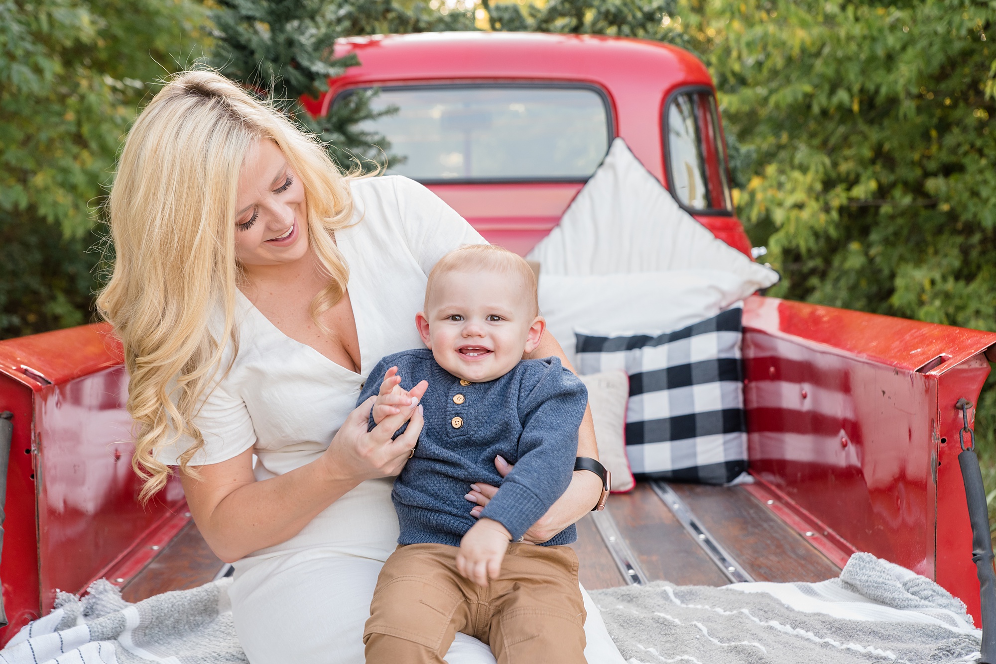 mom holds toddler during Red Truck Christmas minis