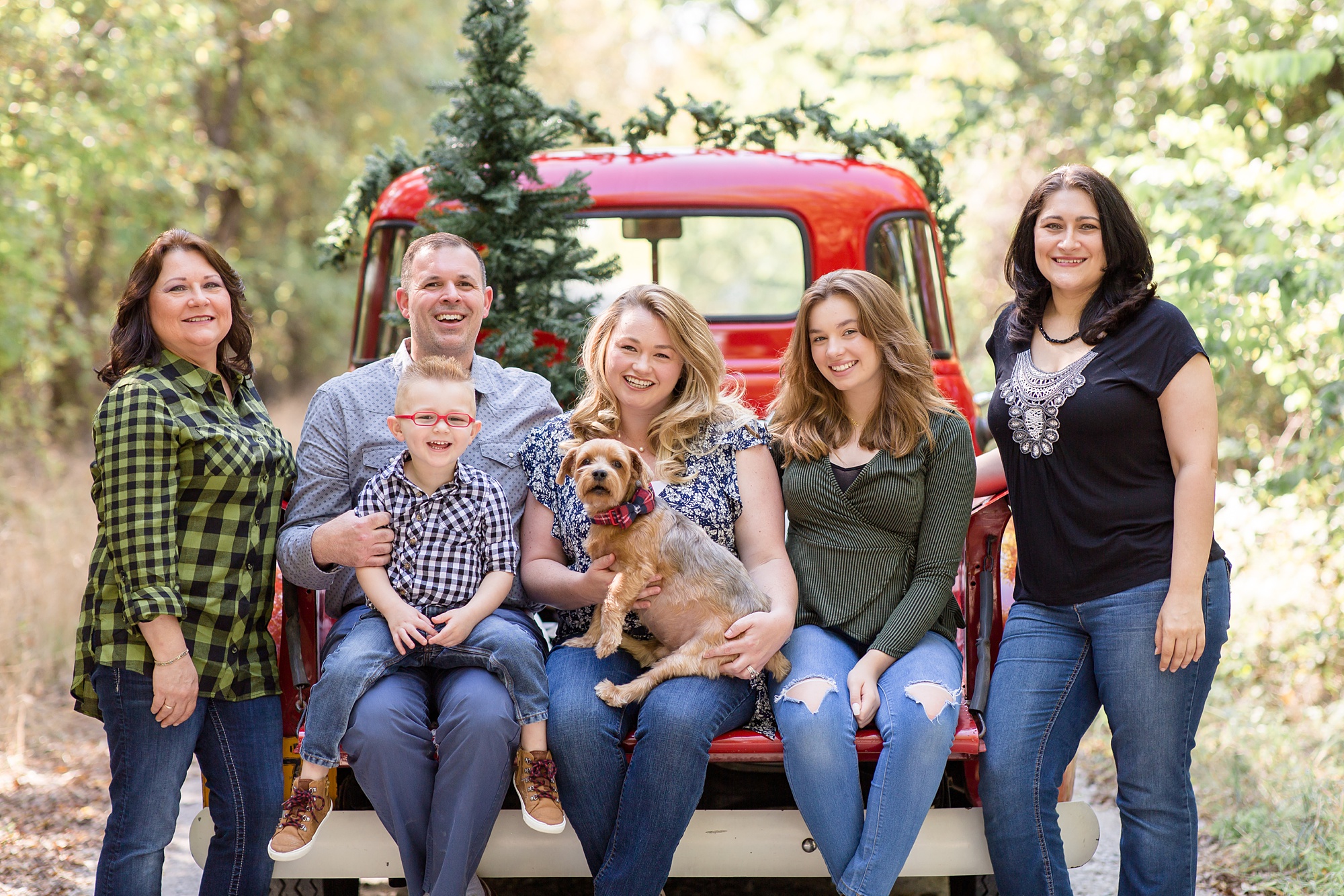 family poses with dog during Red Truck Christmas minis