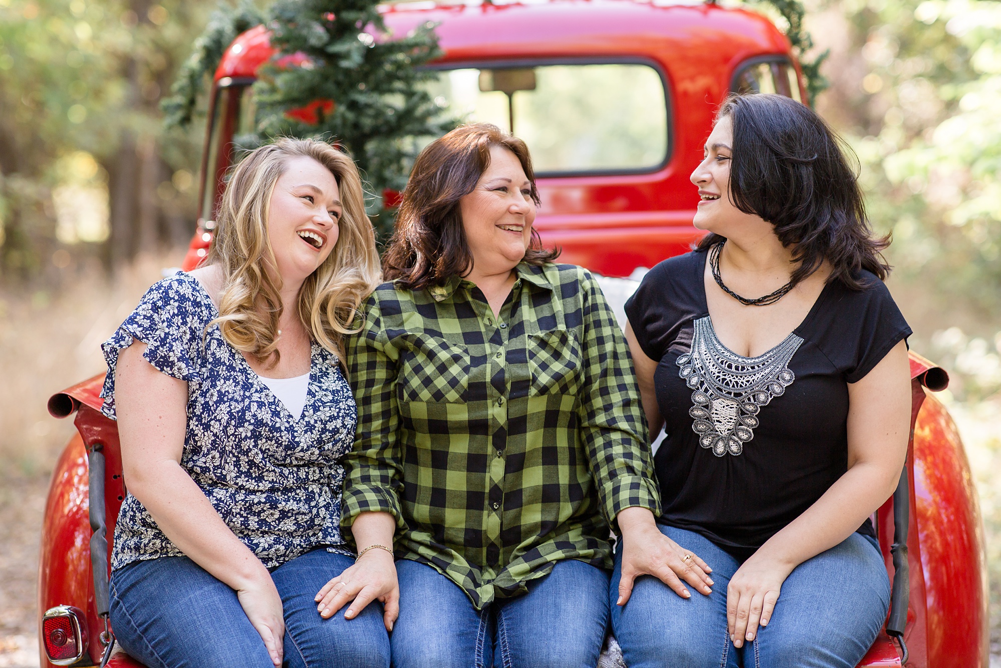 adults sisters laugh during Red Truck Christmas minis