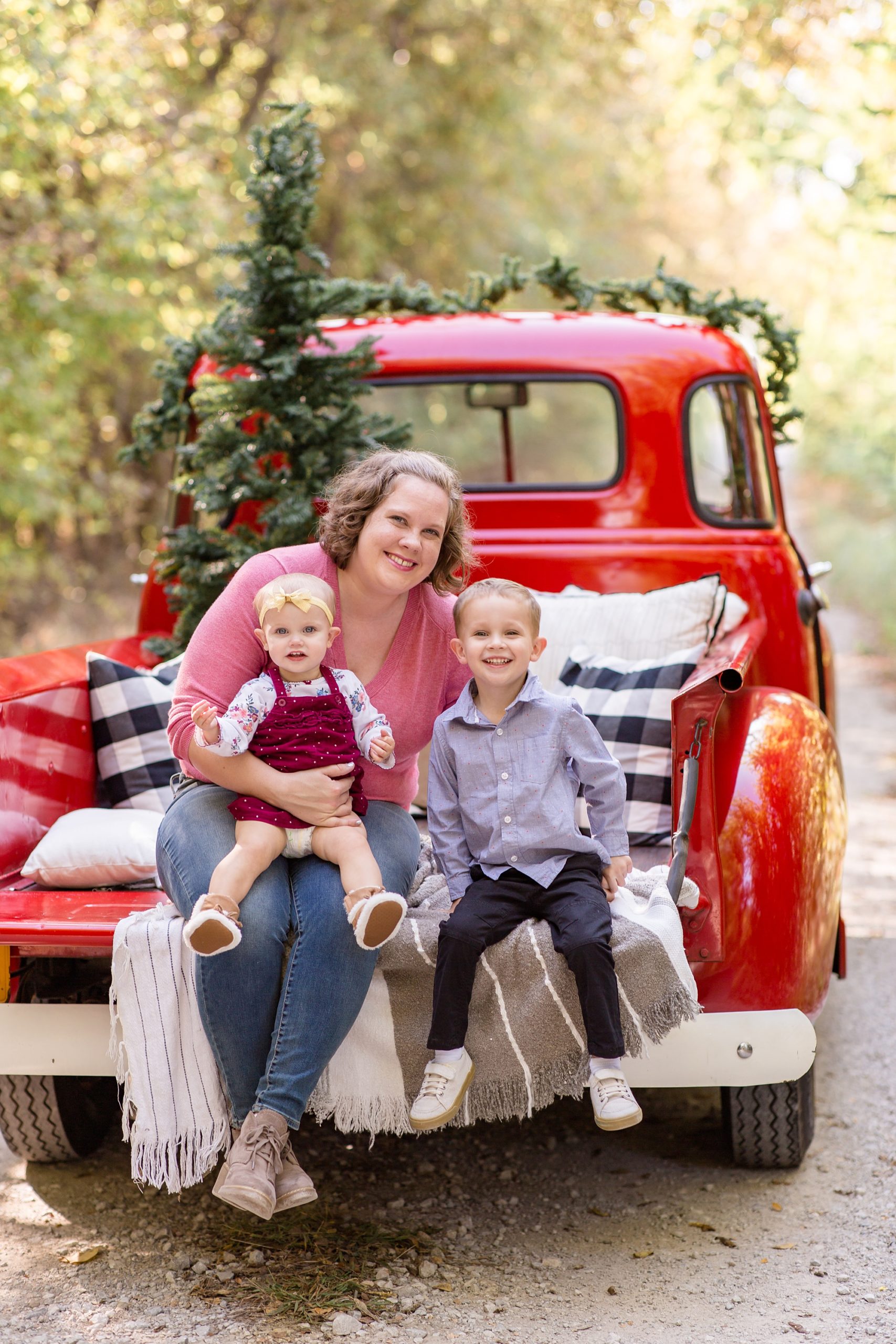mom sits with kids during Red Truck Christmas minis