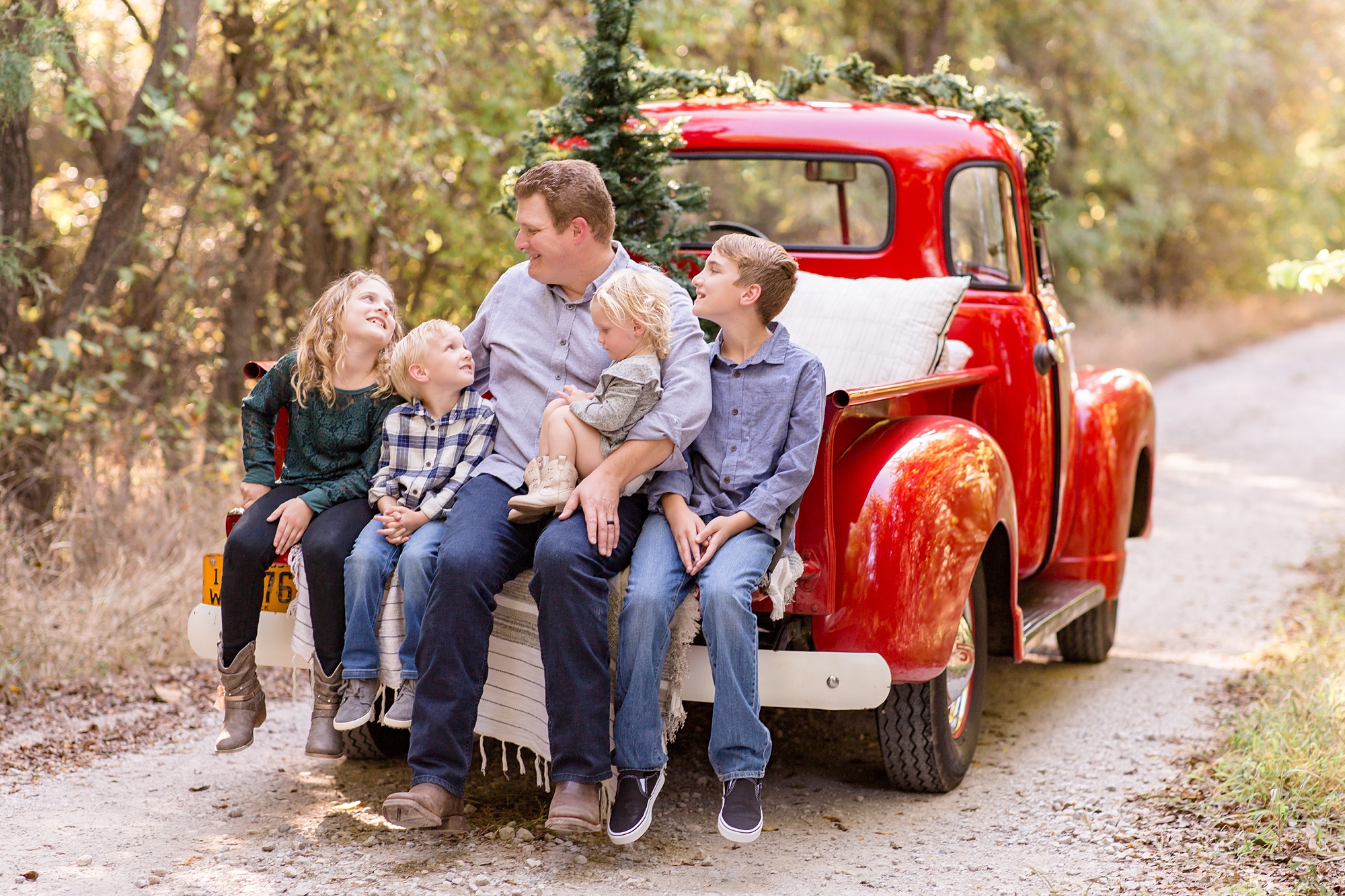 kids sit with dad and look up at him during Red Truck Christmas minis