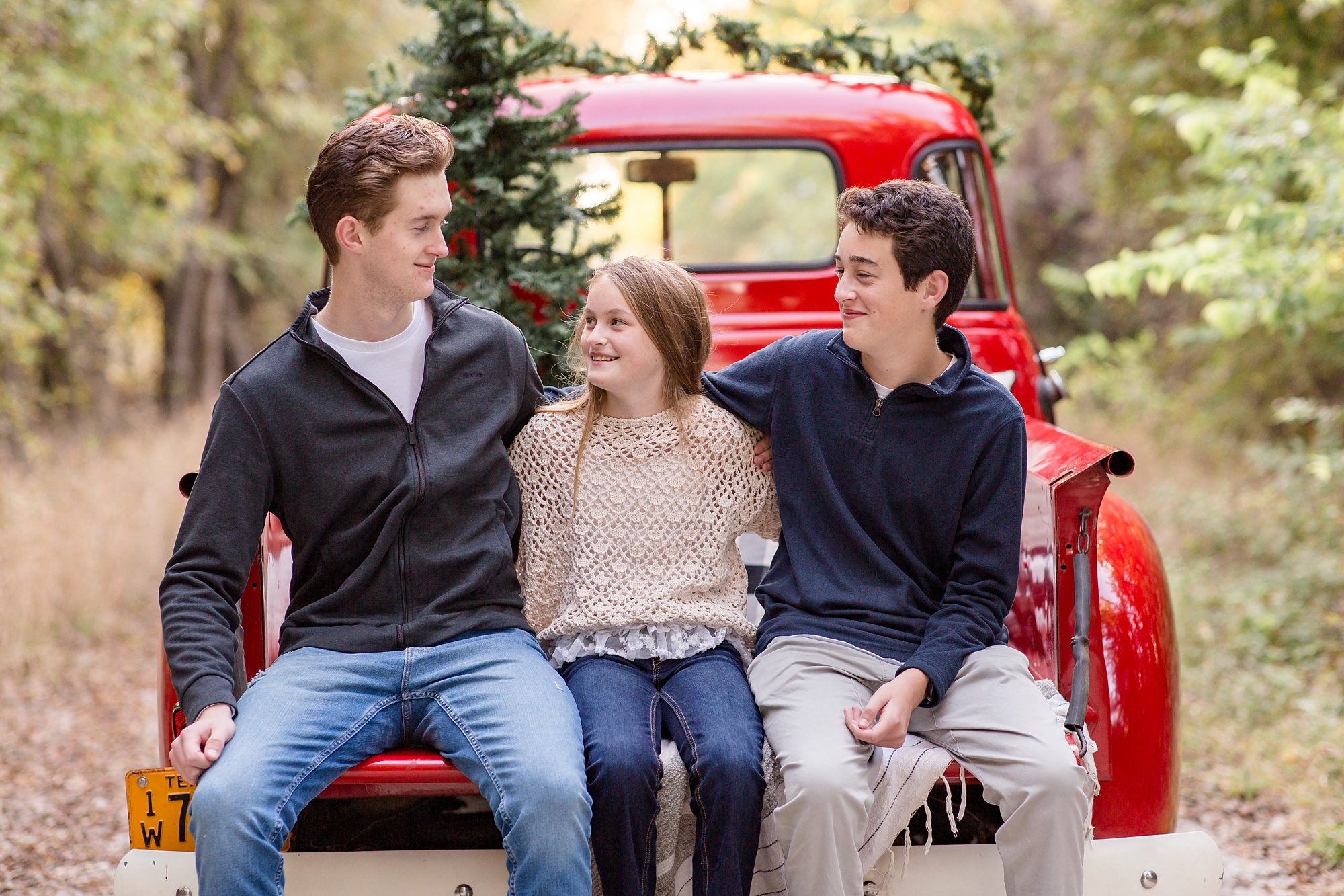 siblings sit on bed of truck during McKinney TX mini sessions