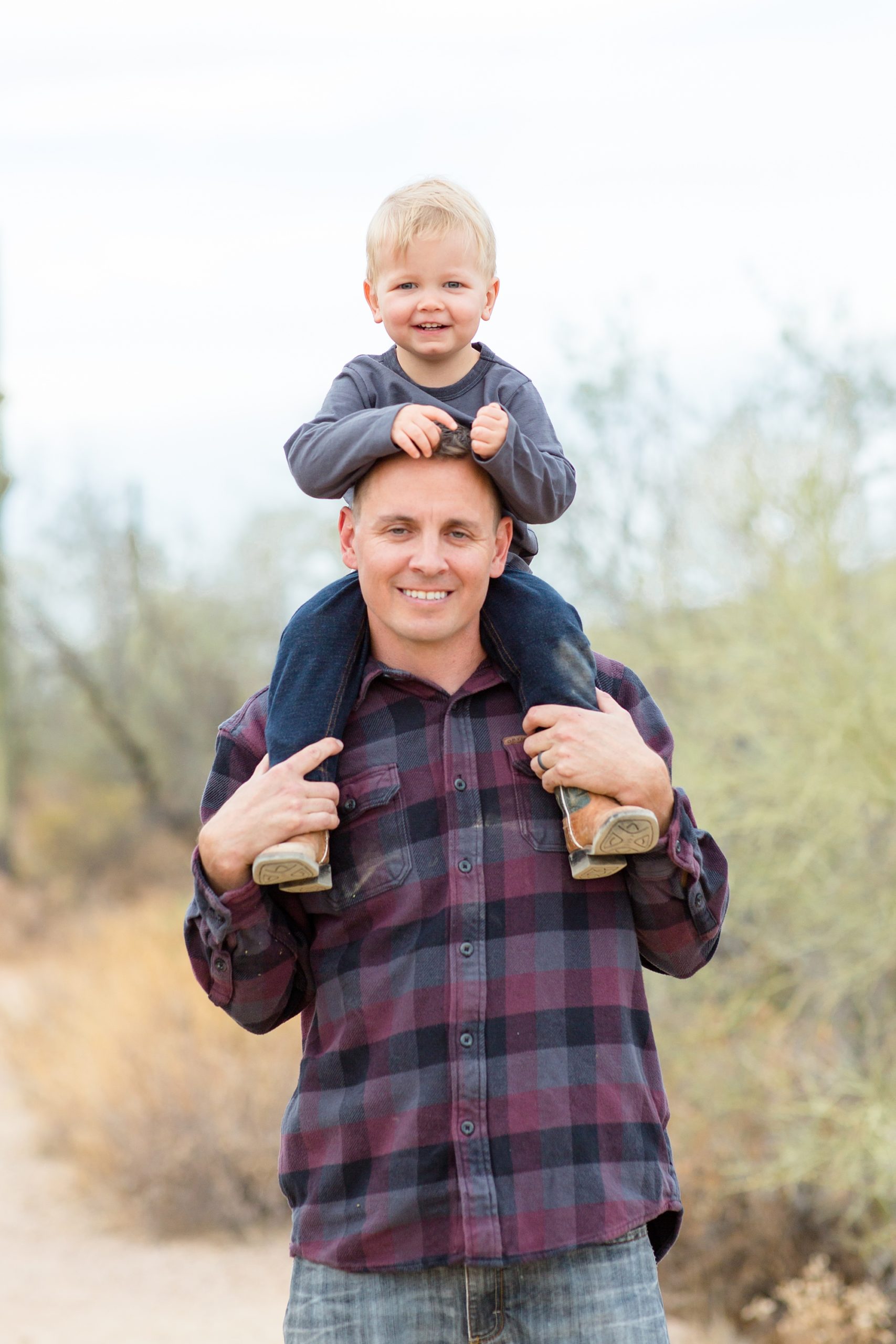 dad holds toddler on his shoulders during fall family photos