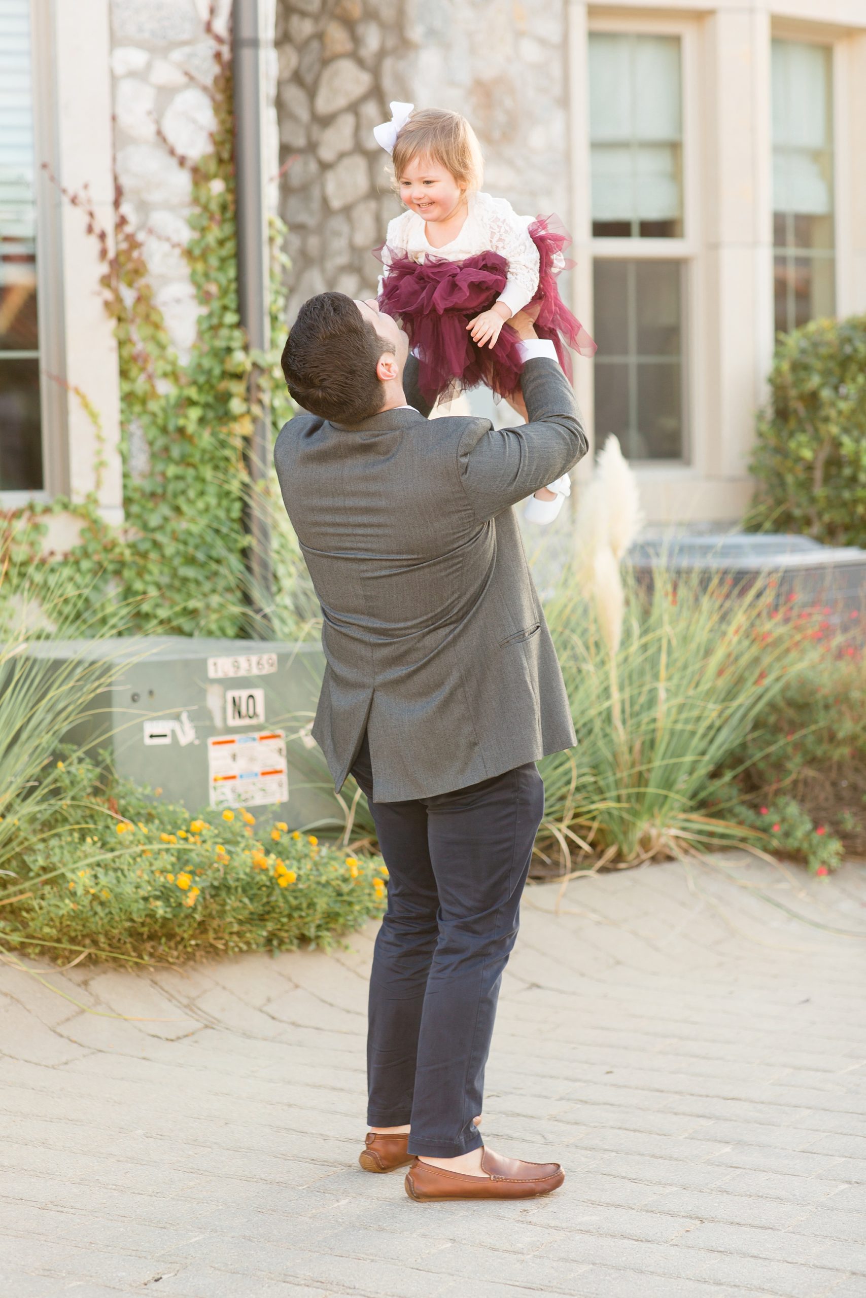 dad lifts daughter in the air during family photos in McKinney TX