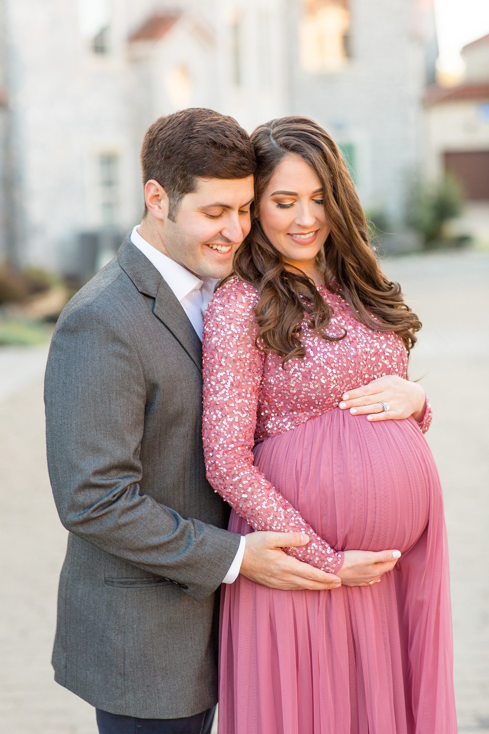 husband hugs wife and holds hand over her belly during McKinney Maternity Session