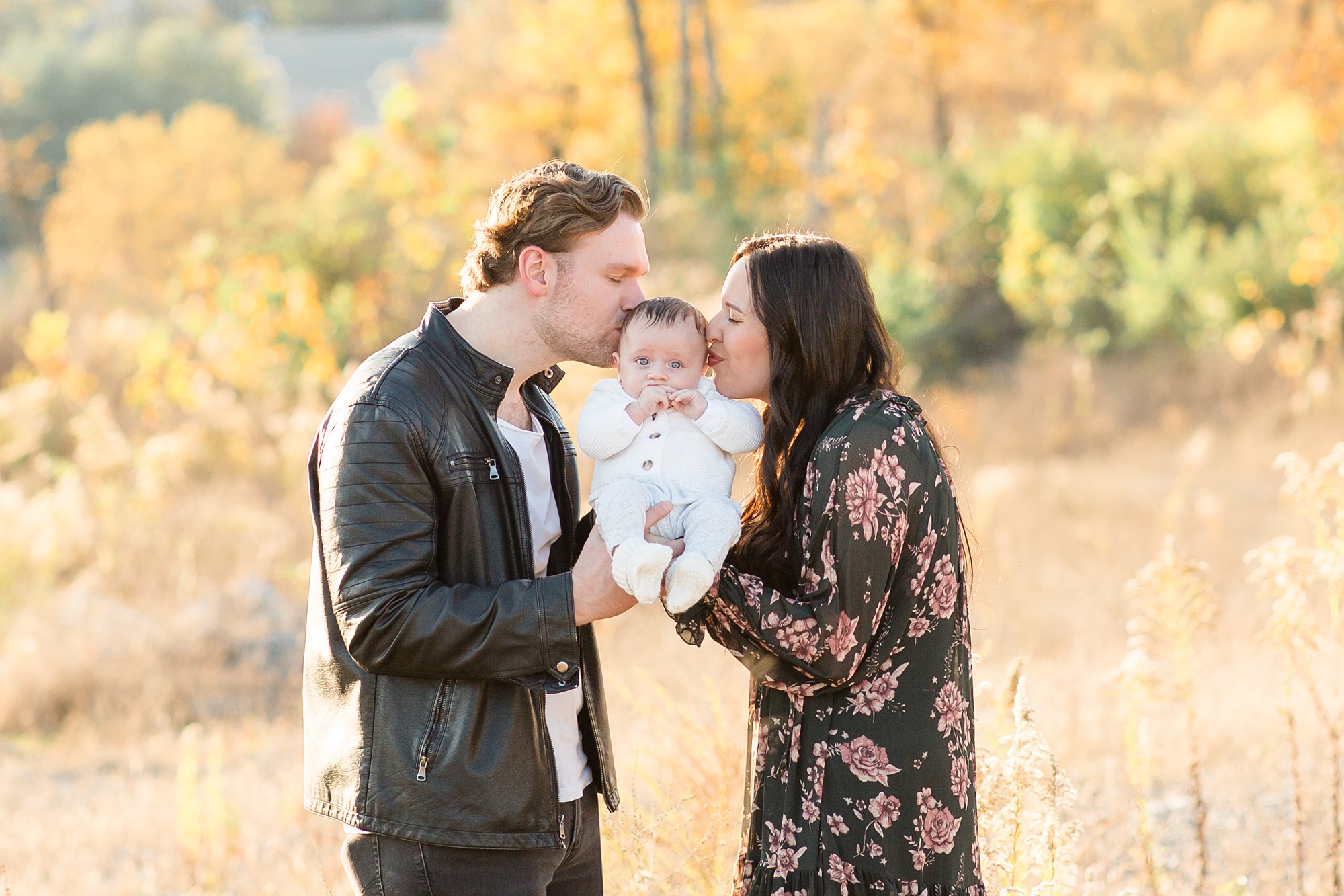 parents kiss baby boy during Nashville family portraits