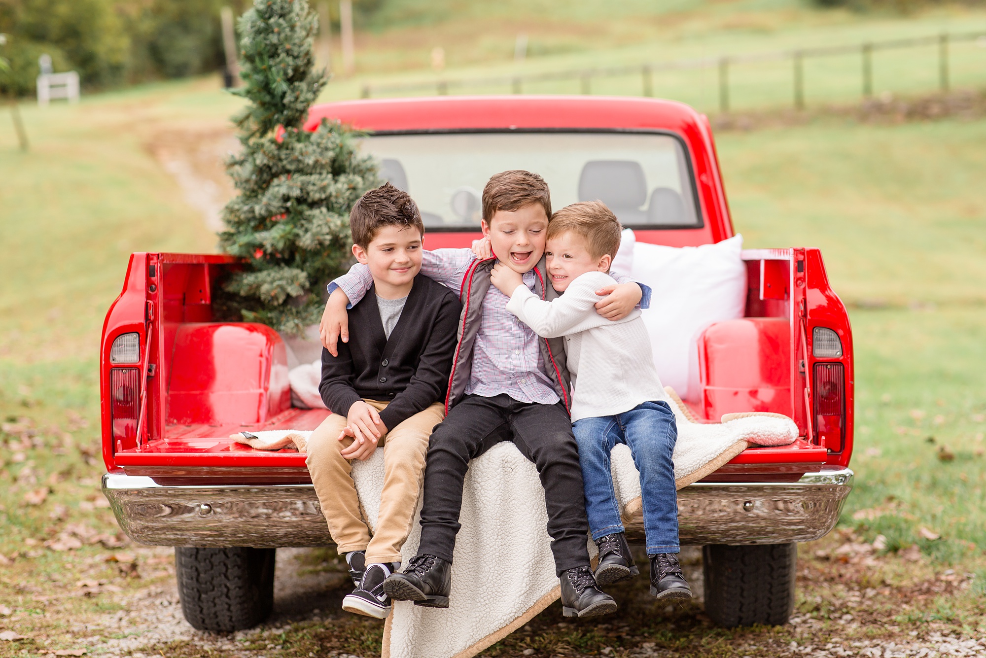 brothers sit on bed of red truck during Tennessee Red Truck Christmas Minis