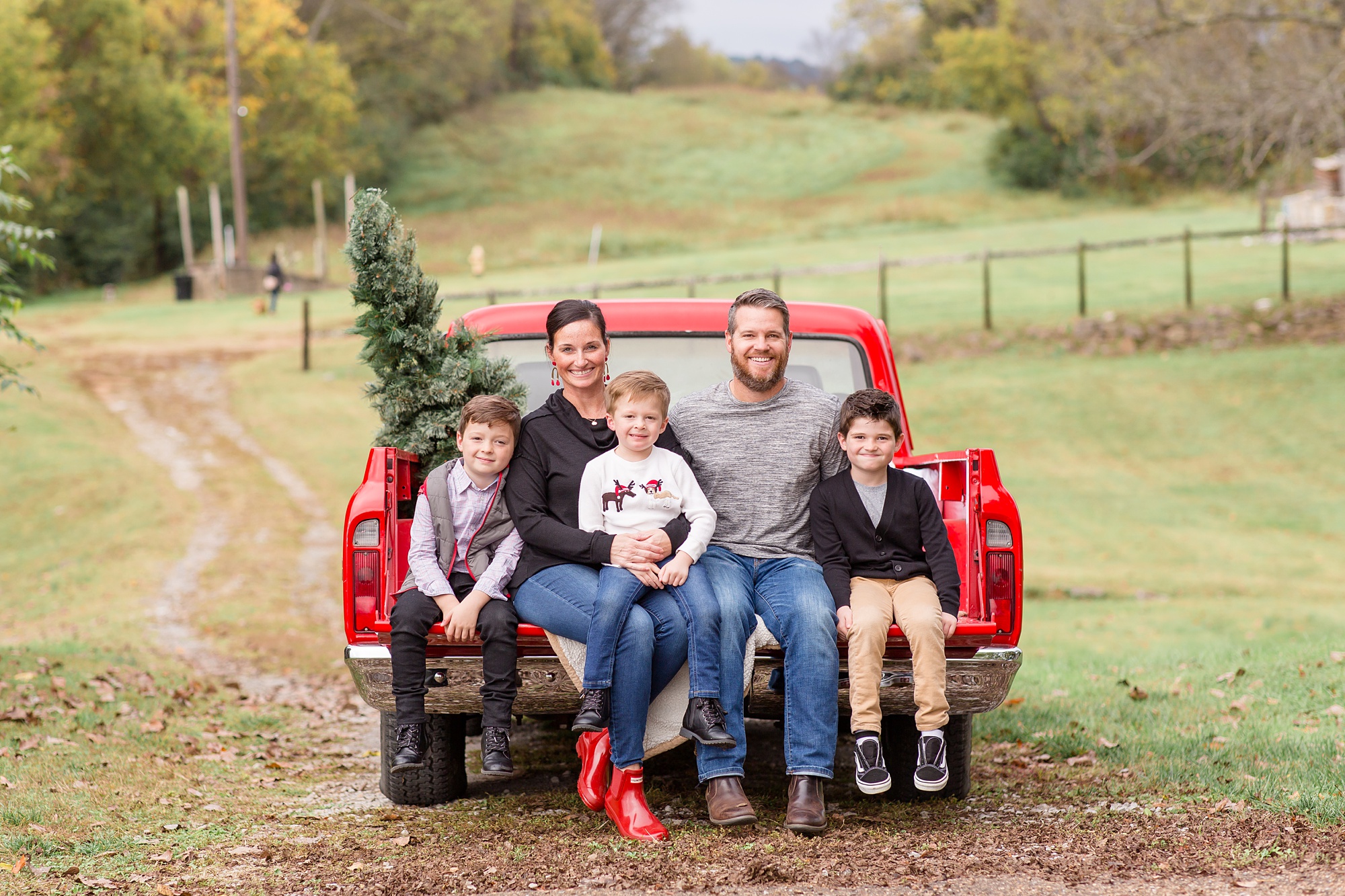 parents pose with three boys during vintage red truck minis
