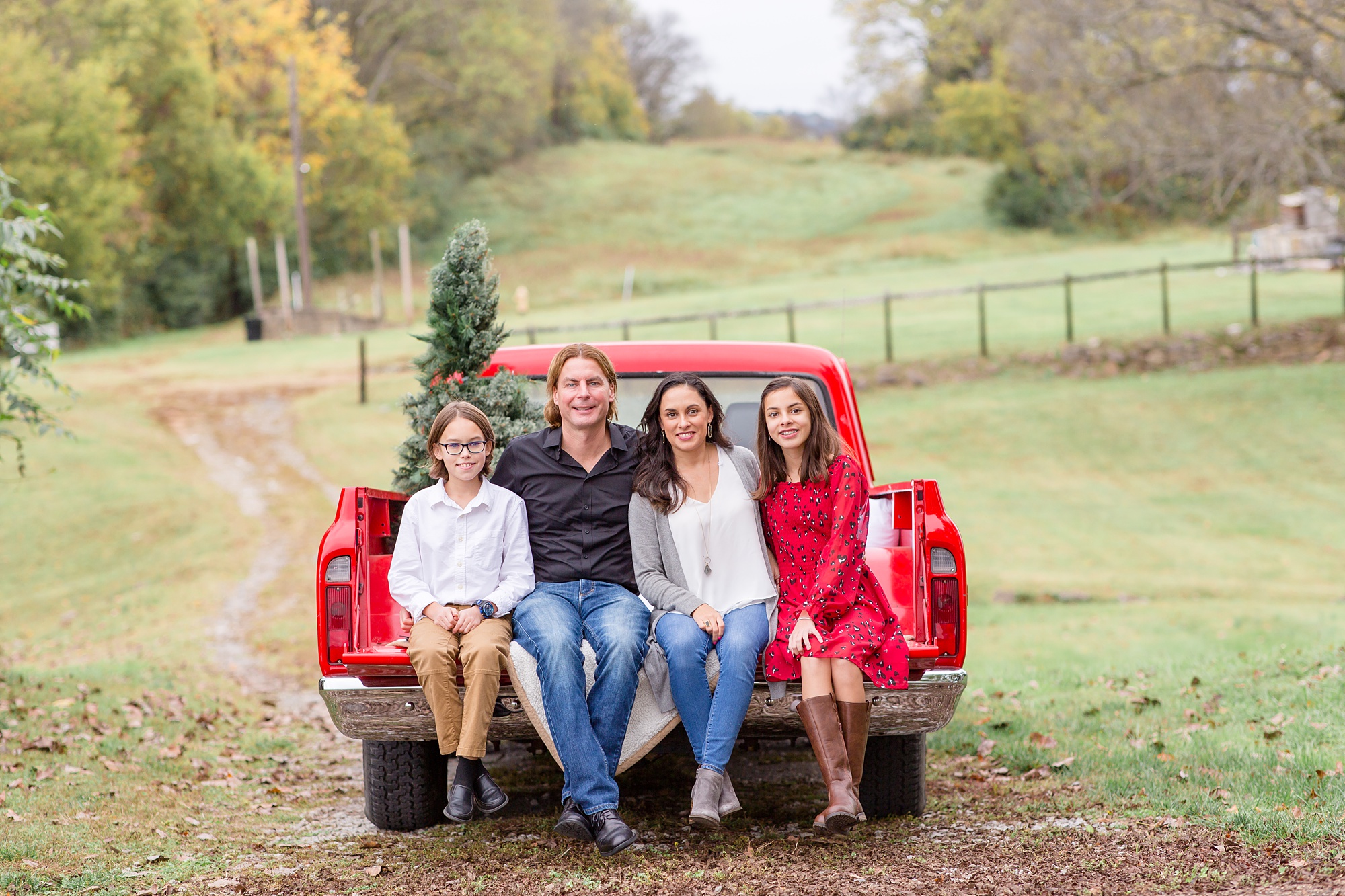 family of four poses during Tennessee Red Truck Christmas Minis