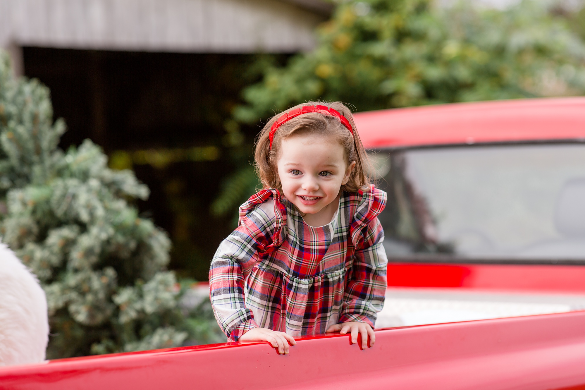 little girl leans over the edge of truck bed