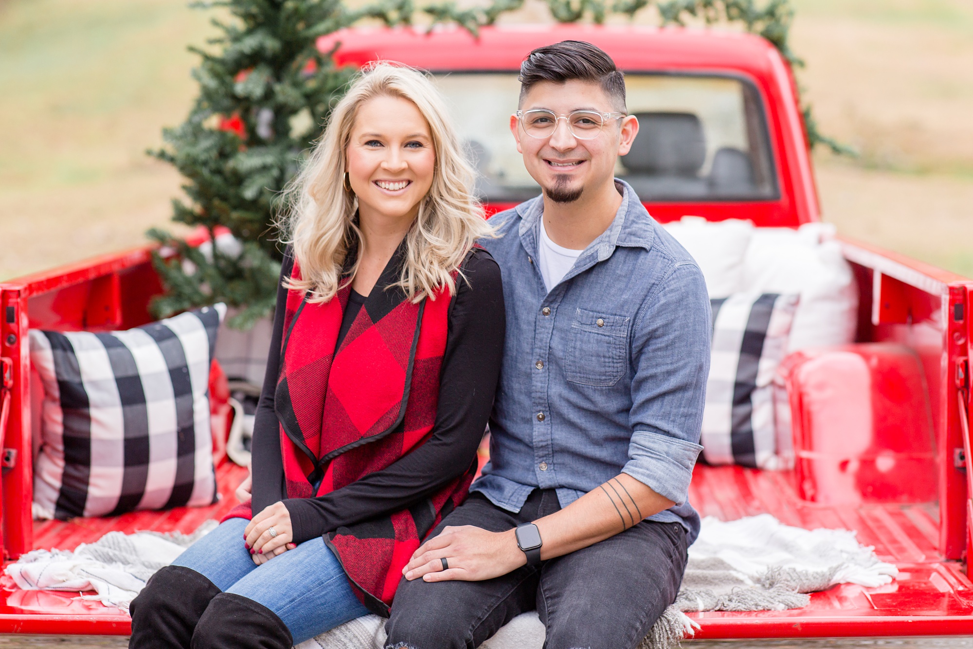 married couple sits in truck bed during Tennessee Red Truck Christmas Minis