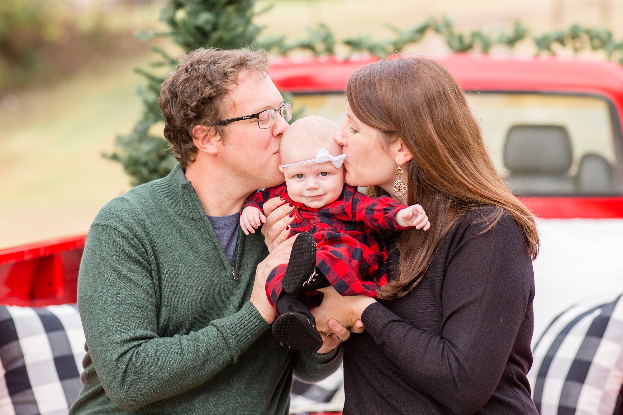 parents kiss little girl during Franklin TN holiday session