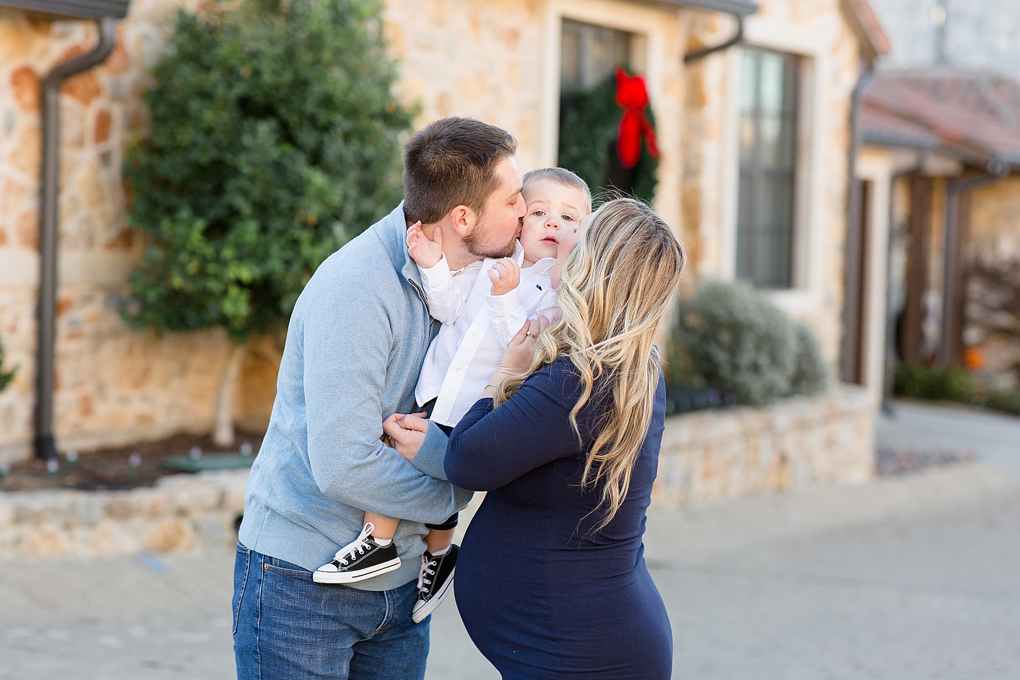 parents kiss toddler during family photos in Texas