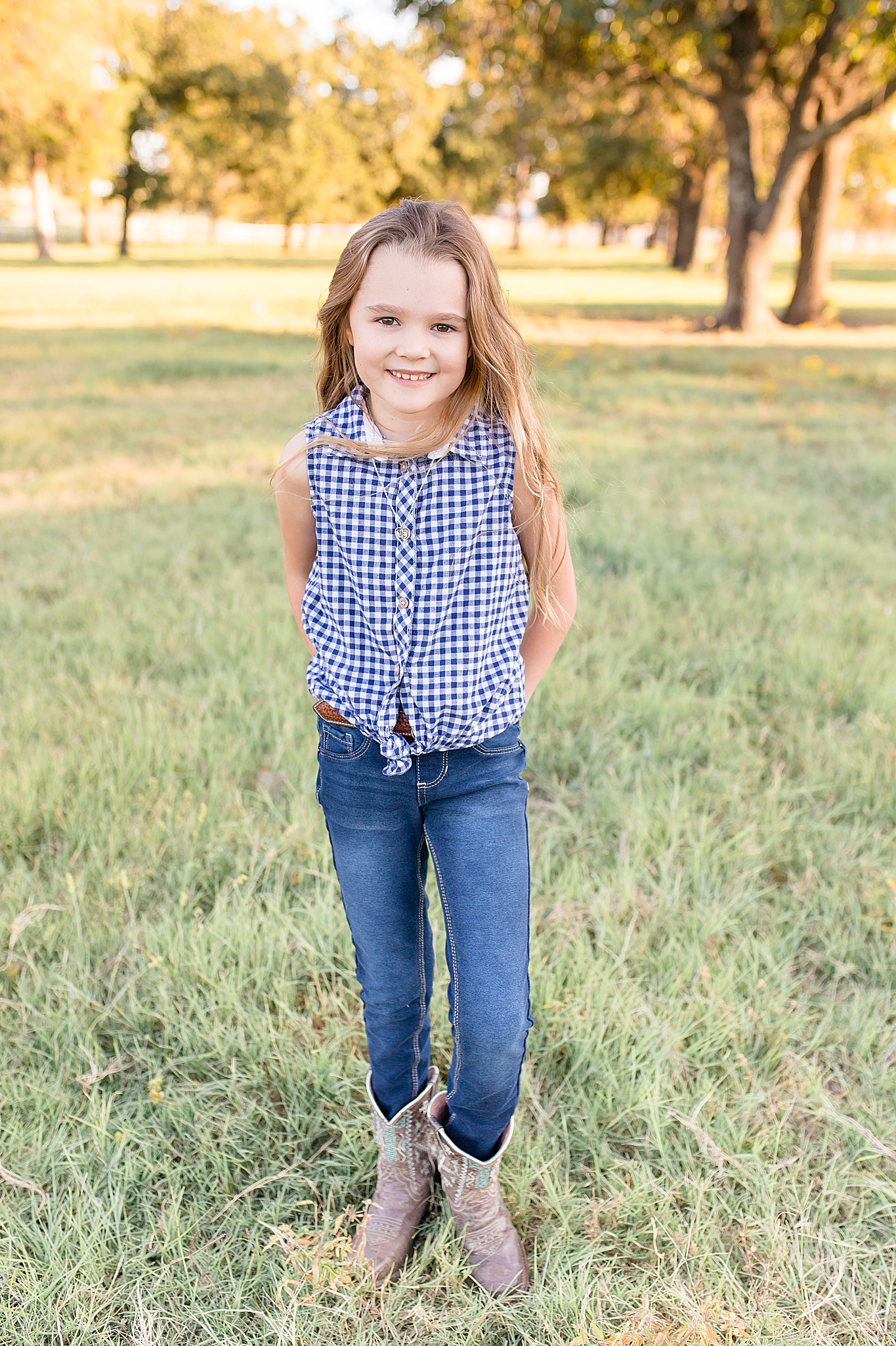 daughter in gingham shirt poses on family farm