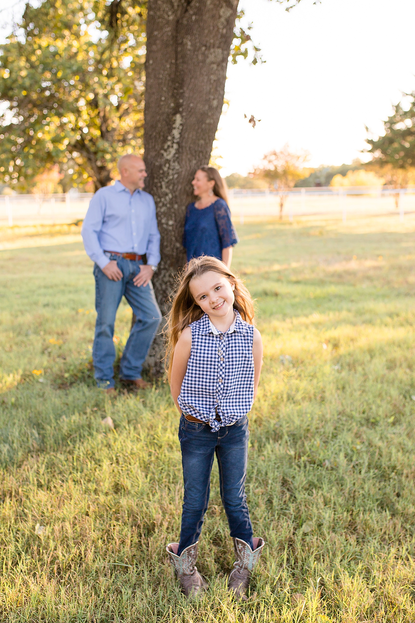 little girl stands in front of parents during McKinney TX family photos