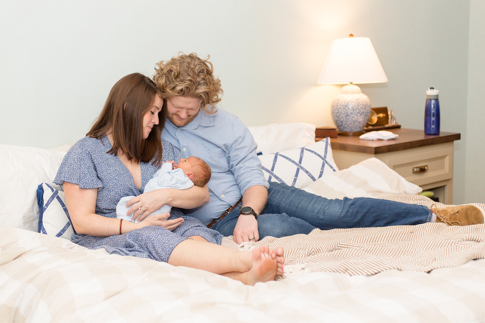 parents look down at baby boy during Nashville lifestyle newborn portraits