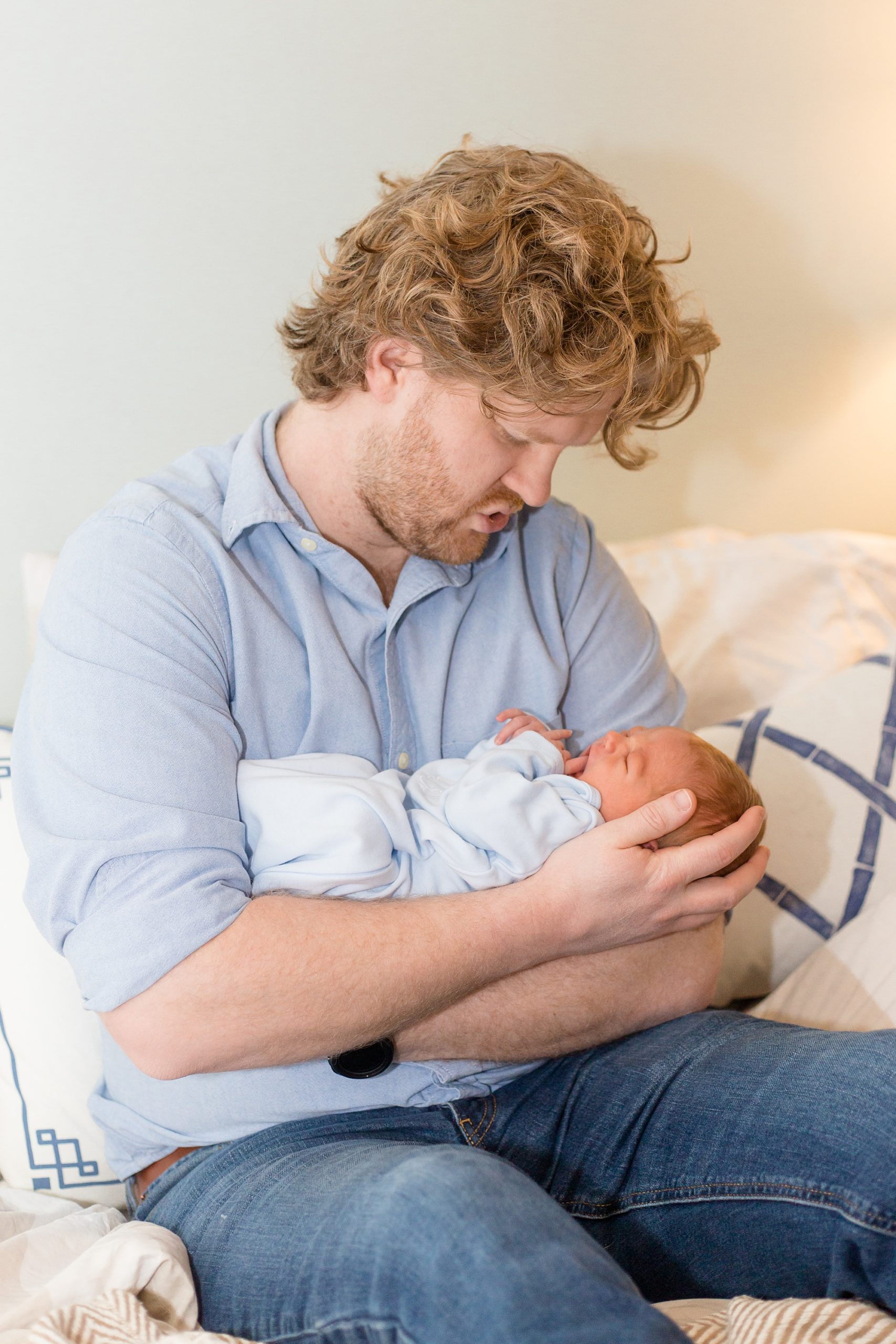 dad holds baby boy during newborn photos at home